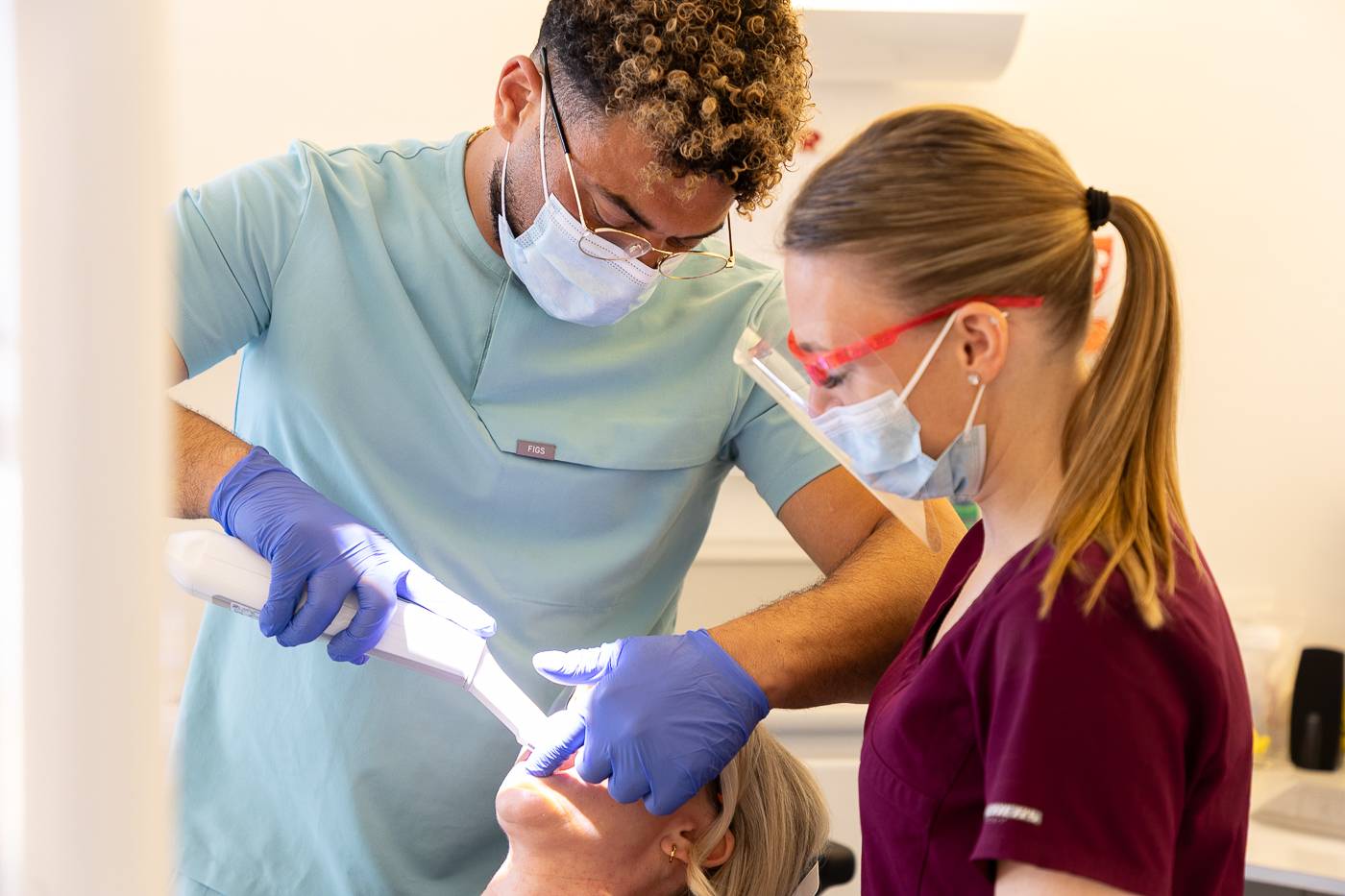 Tariq and Sadie scan a patient's mouth using the intraoral scanner