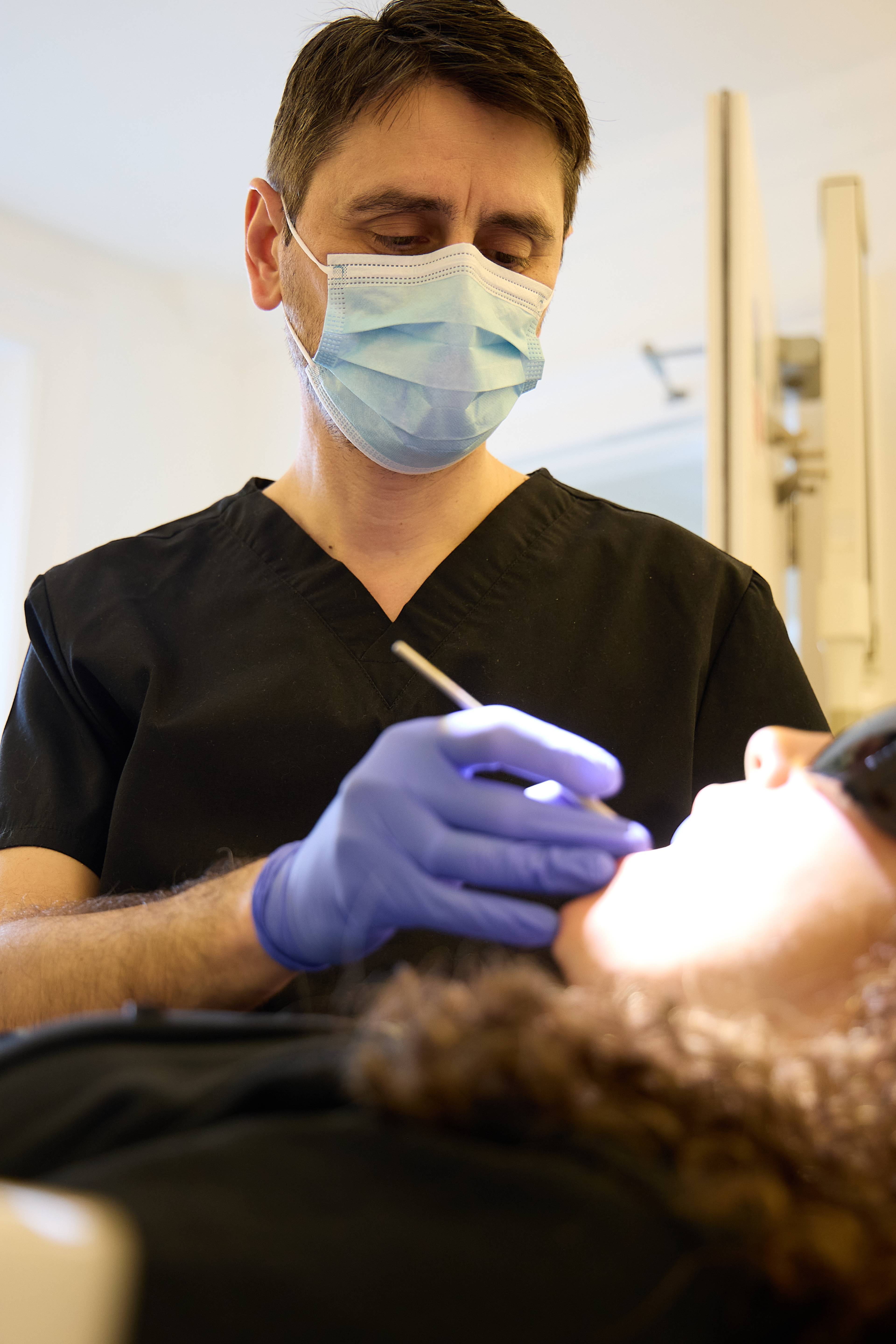 Oreste Gheorghe examining a patient's teeth