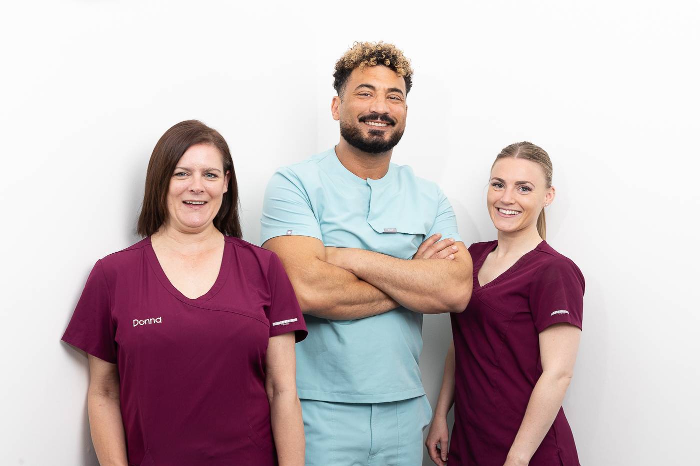 Tariq and two dental nurses smiling at the camera