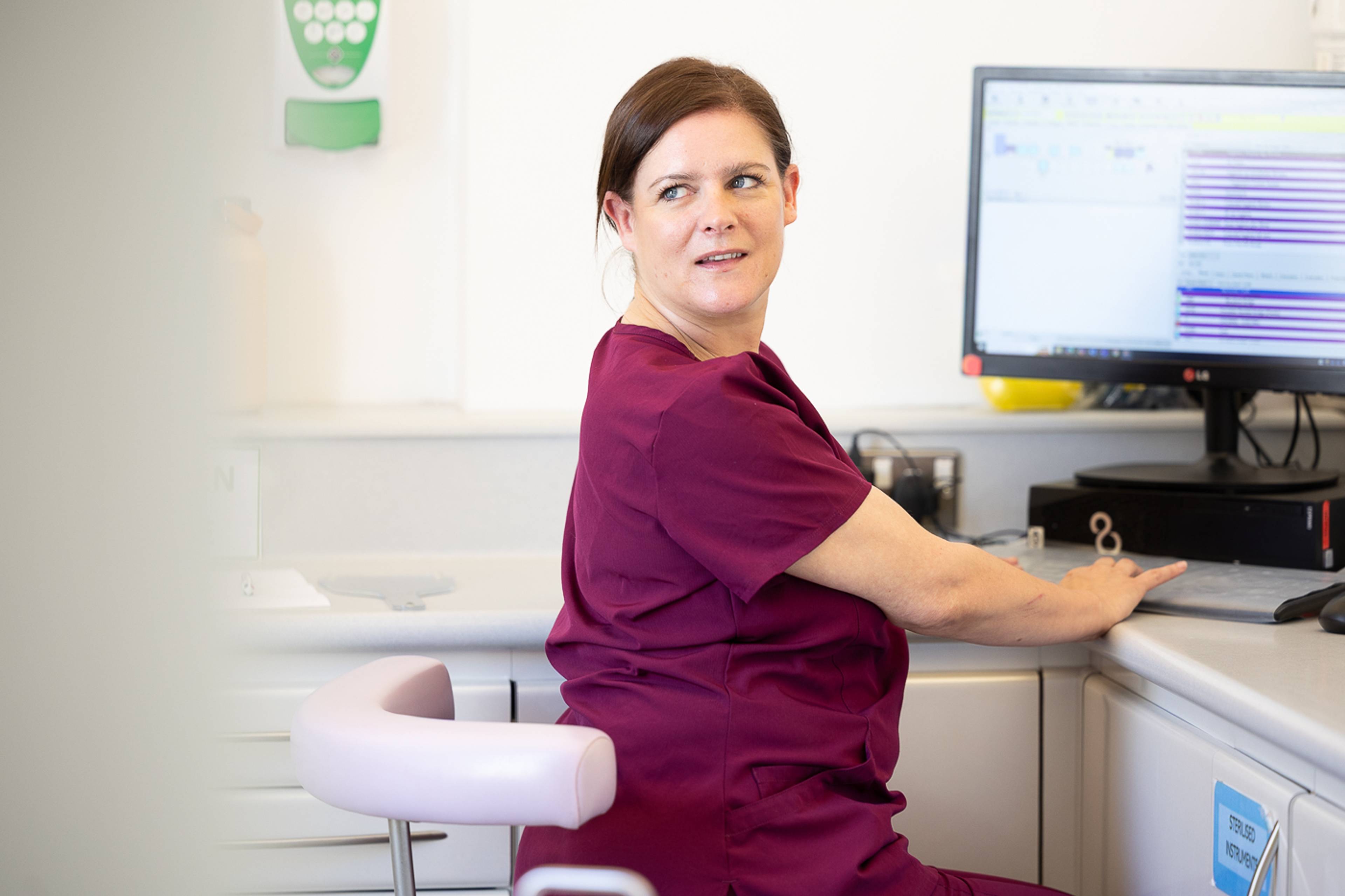 A dental nurse working at a computer