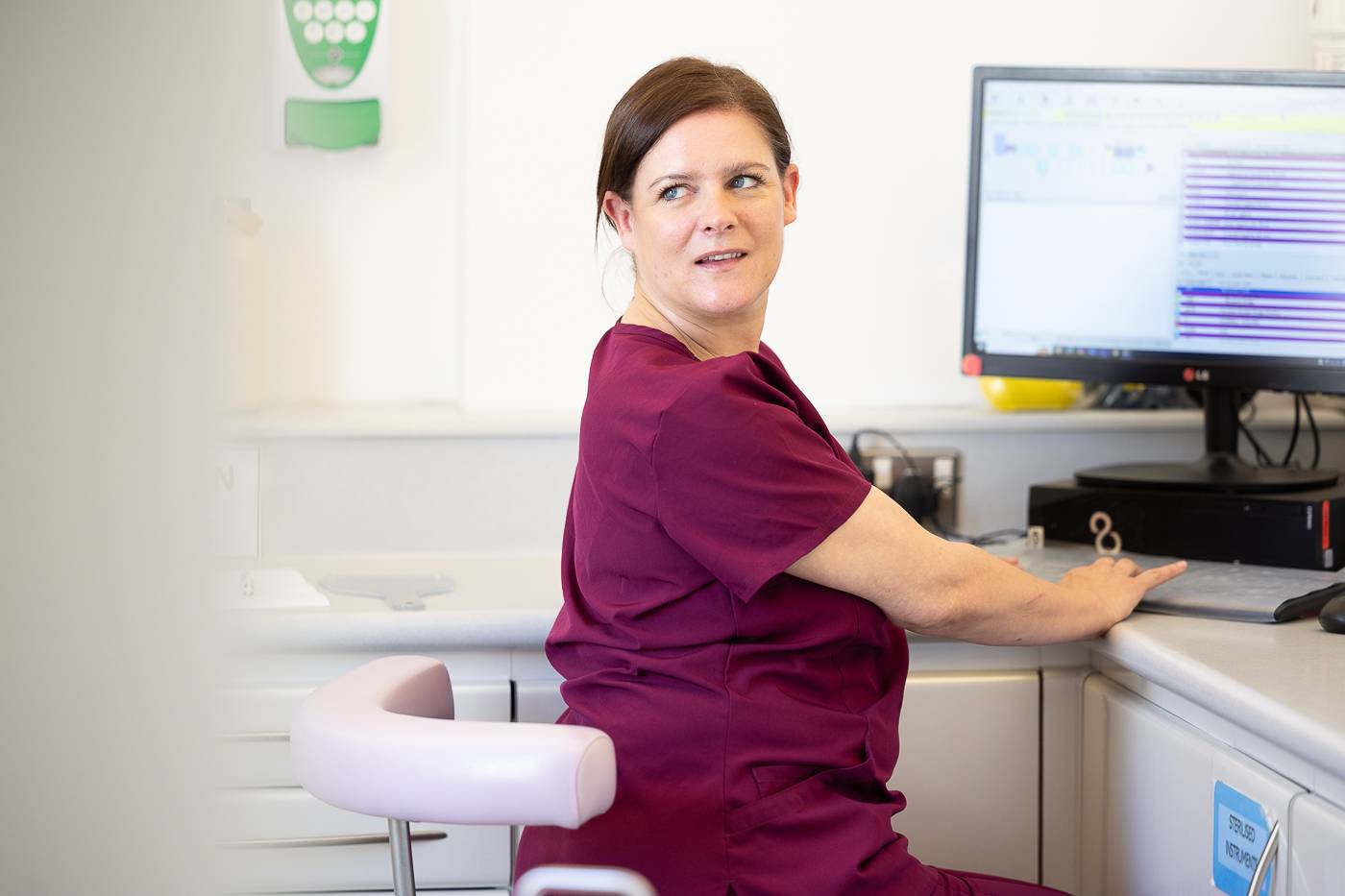 A dental nurse working at a computer