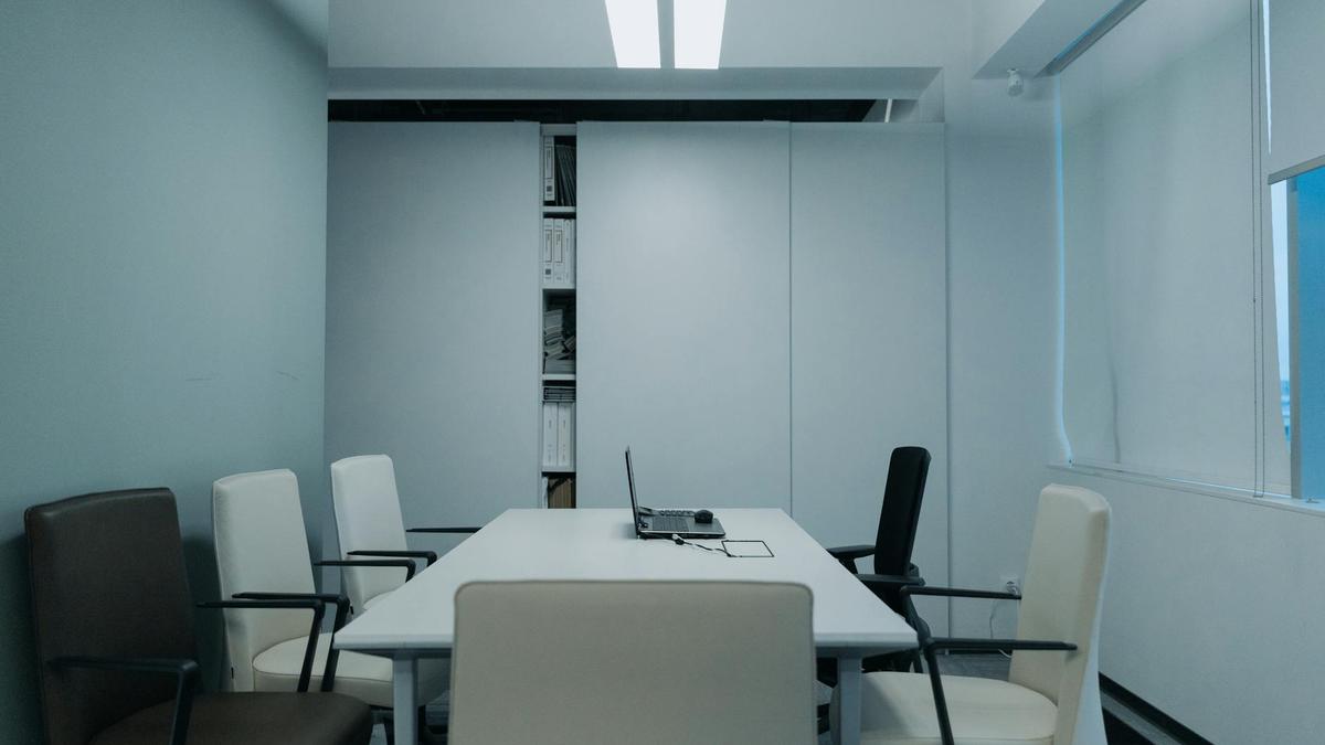 Modern conference room with minimalist design and neutral color palette, showcasing simplicity in workspace.
