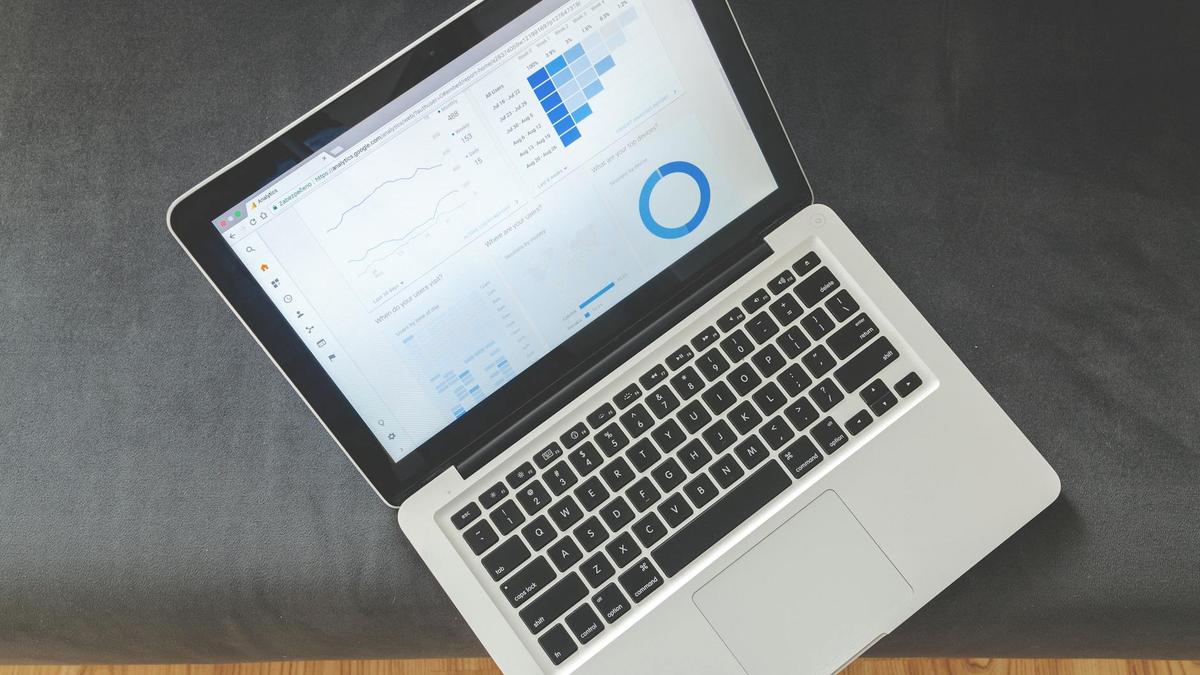 Overhead view of a laptop showing data visualizations and charts on its screen.