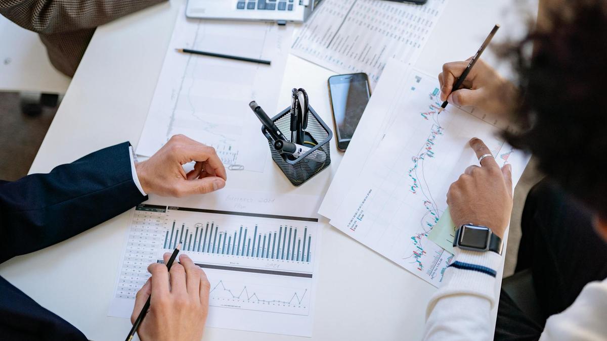 Business team analyzing financial charts and graphs during a collaborative meeting.