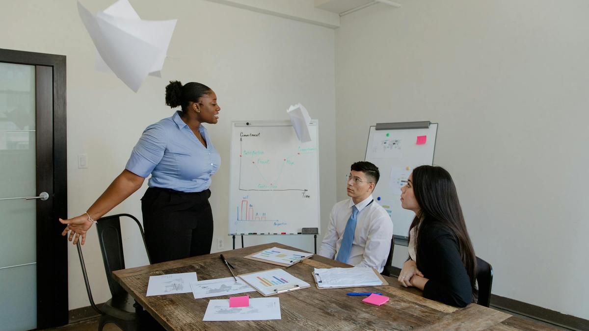 A group of colleagues engaged in a lively discussion in a modern office setting, emphasizing teamwork and collaboration.