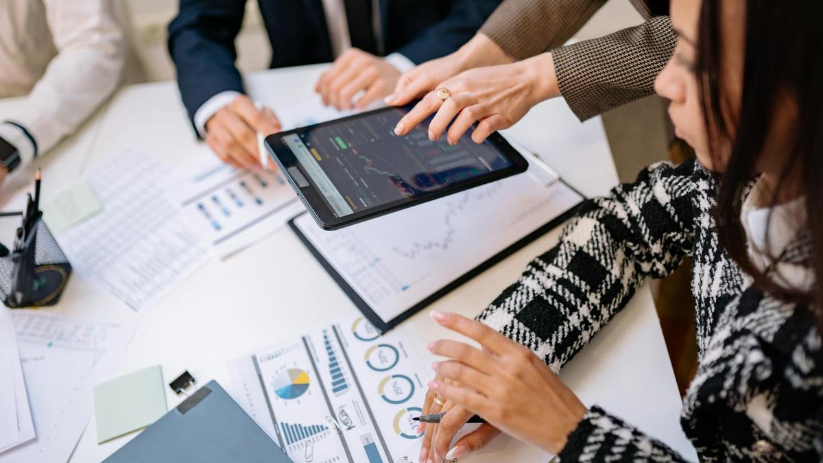 Business professionals reviewing analytics on a tablet during a meeting.