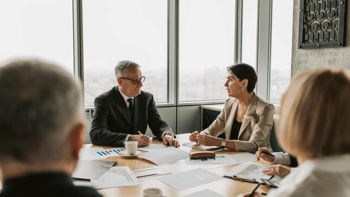 Business professionals engaged in a strategic meeting in a modern office setting with natural light.