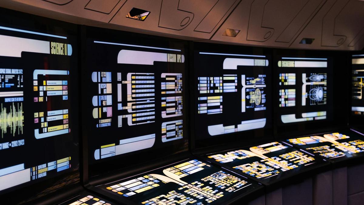 A high-tech command center with illuminated digital screens in a futuristic setting.