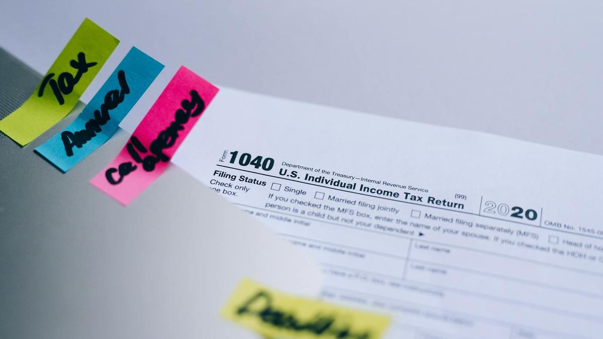 Close-up of 1040 U.S. tax form with colorful sticky notes for organization.