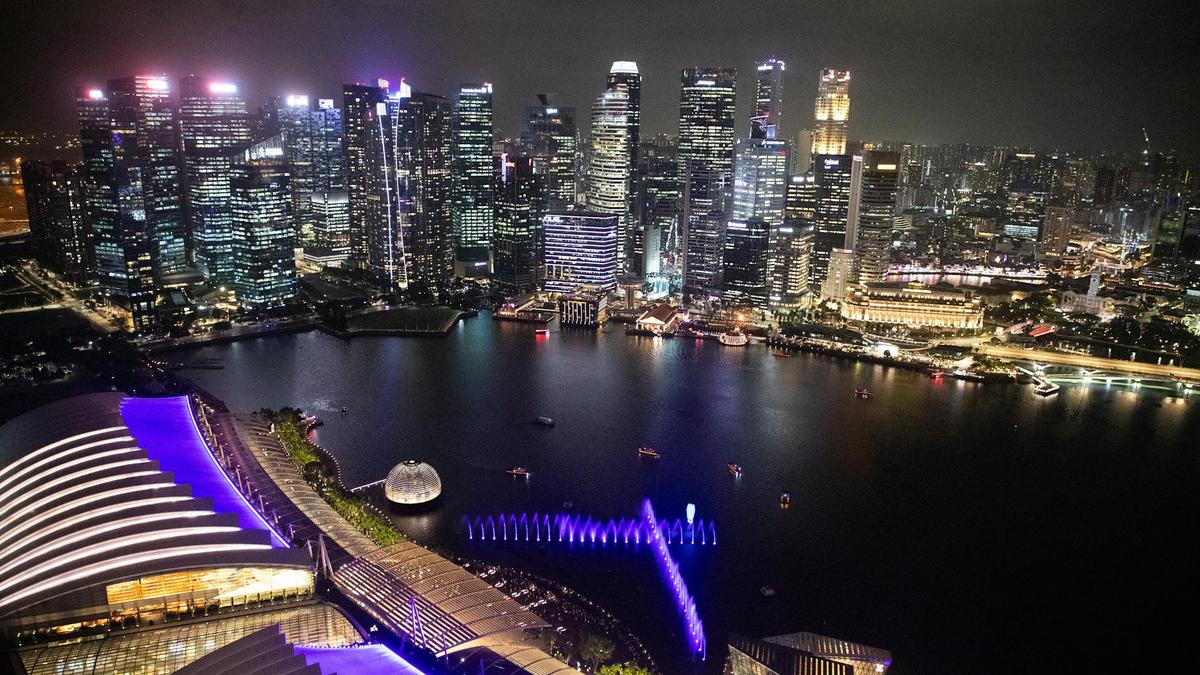 Breathtaking aerial view of Singapore's illuminated skyline at night, showcasing modern architecture and vibrant city life.