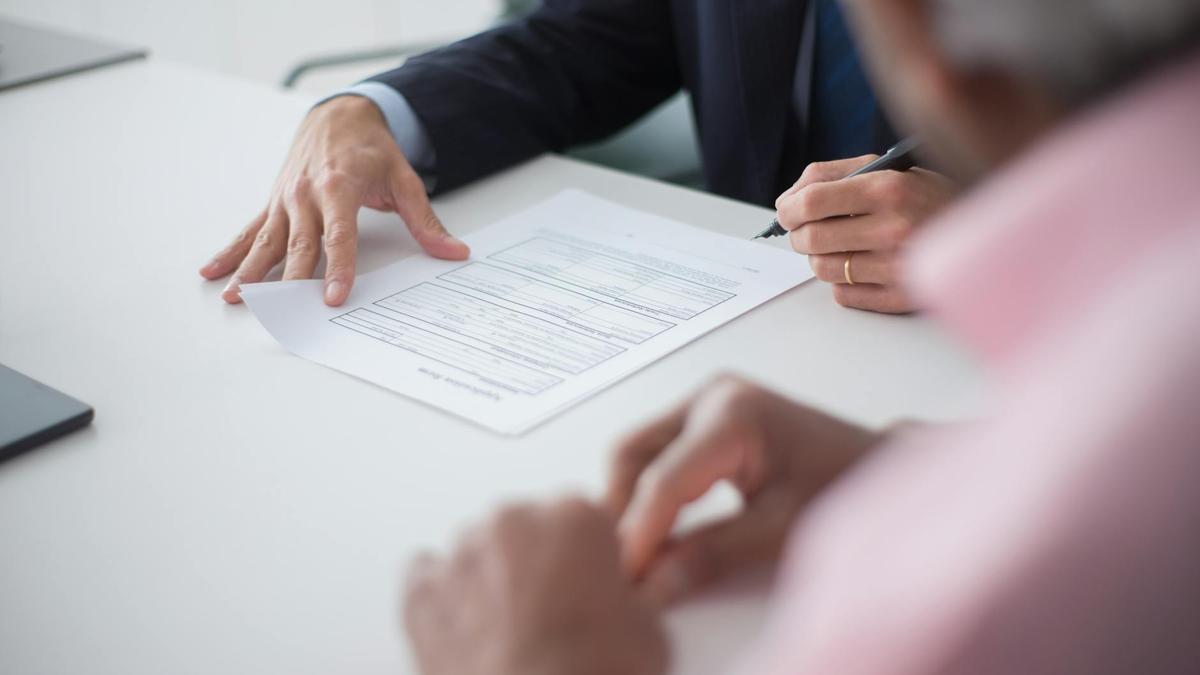 Two professionals engaging in a business meeting, signing documents for a consulting agreement.