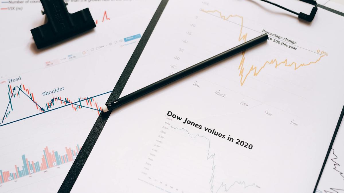 Clipboard with stock market charts and graphs representing financial data analysis.