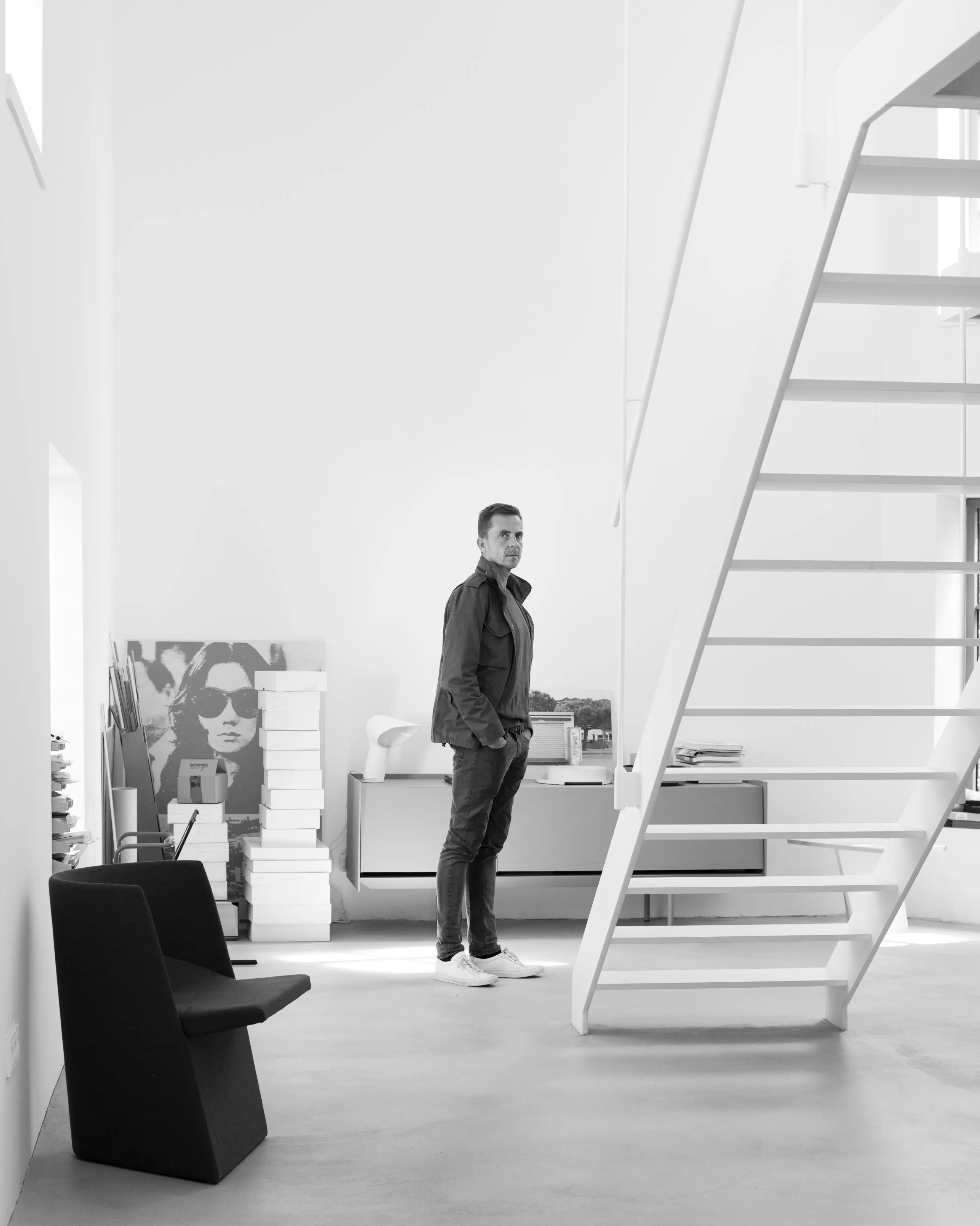 Eric Degenhardt standing in a white studio beside an open staircase