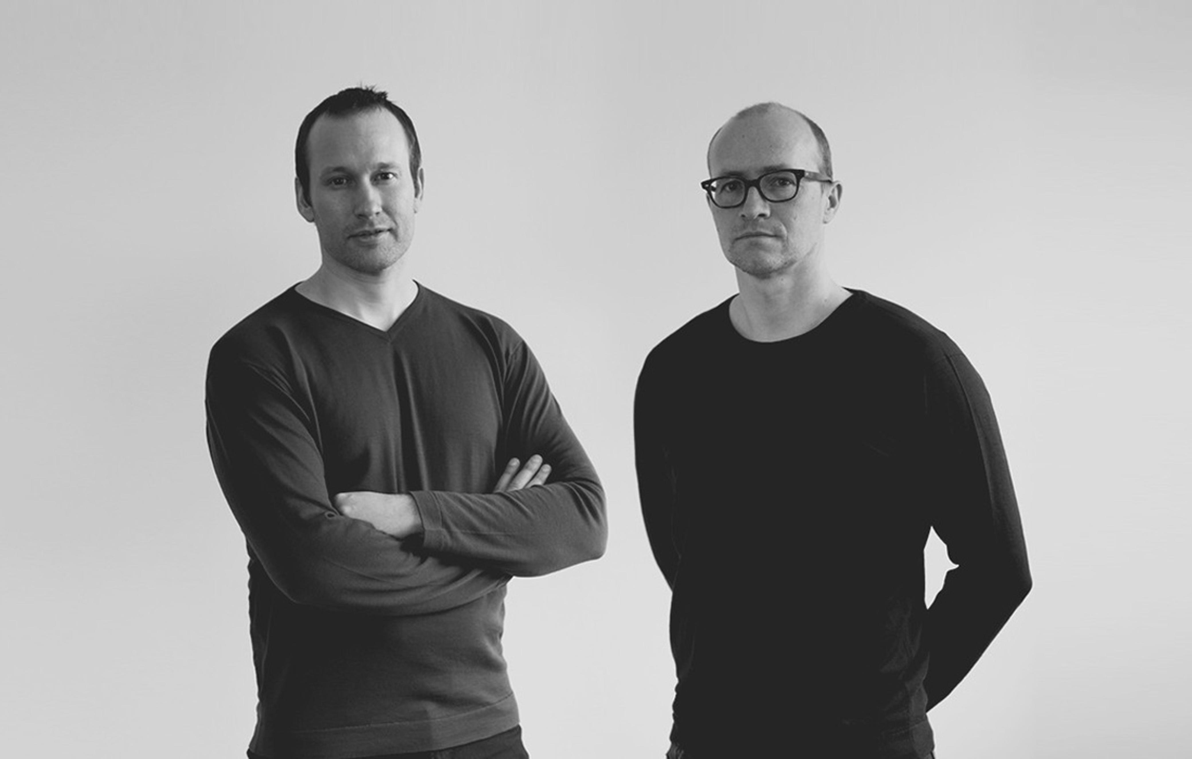 Anderssen & Voll standing side by side against a pale wall