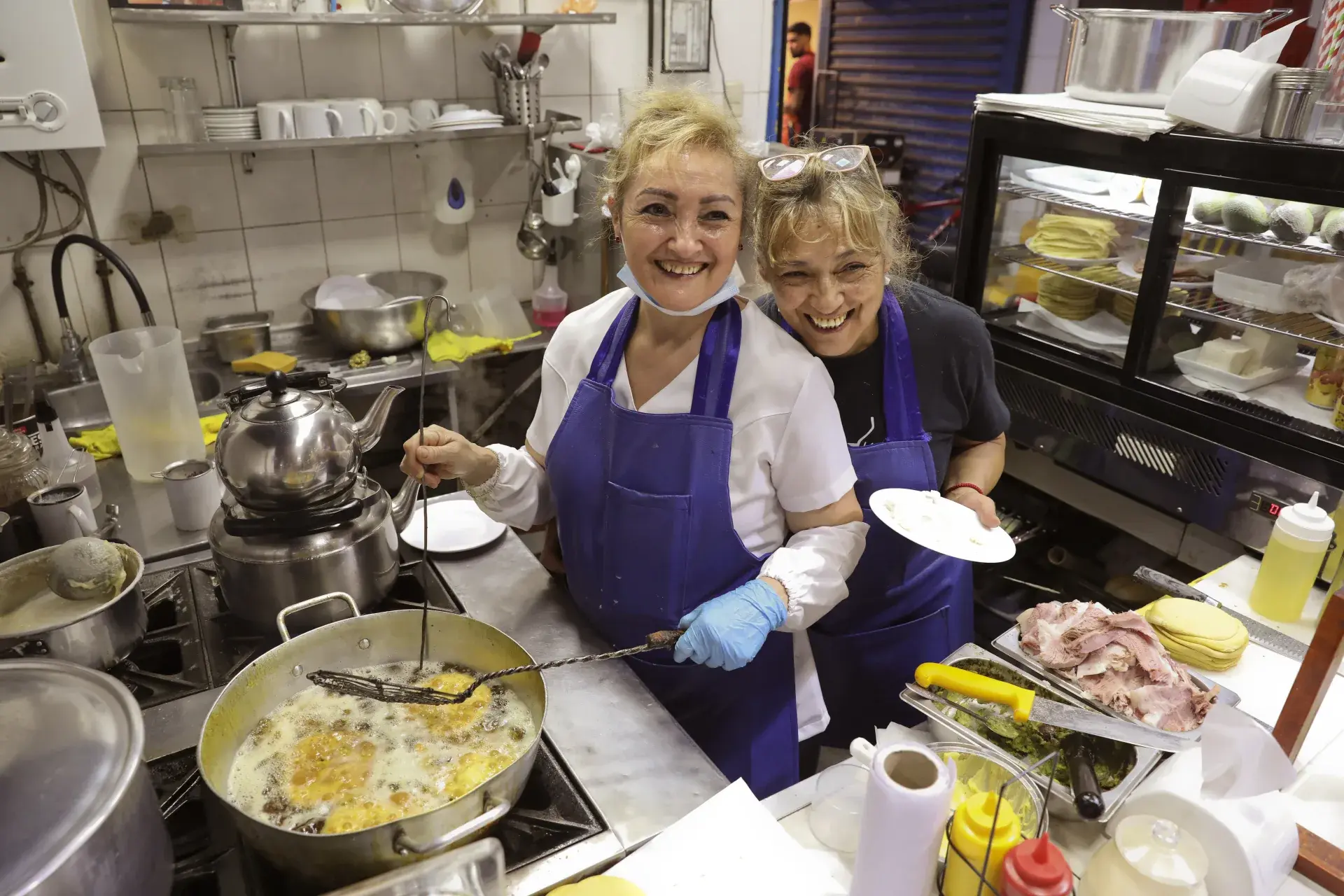 Dos integrantes del equipo de Desayunos Olguita en la cocina del local