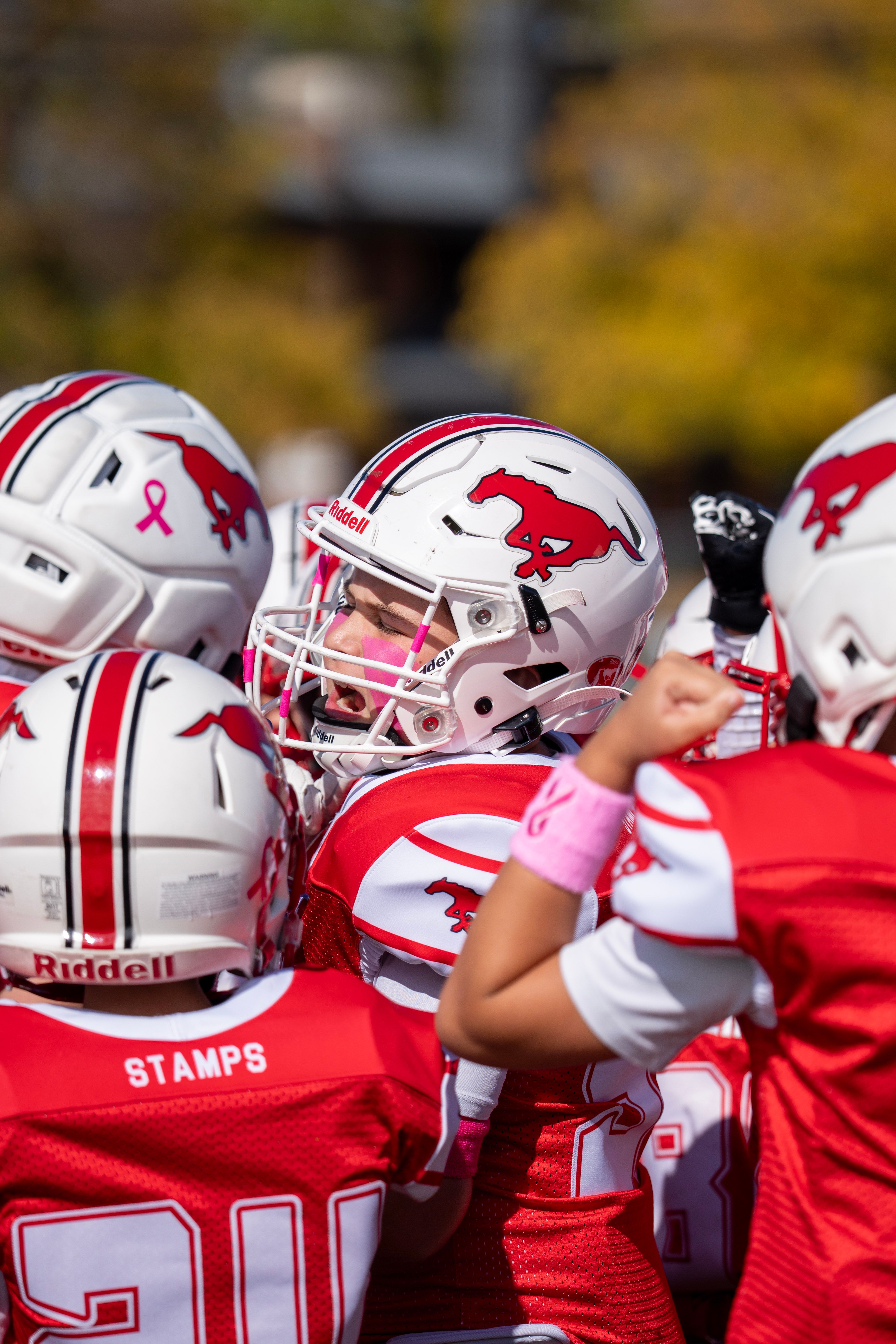 Two Burlington Stampeders players meet helmet-to-helmet before kickoff.