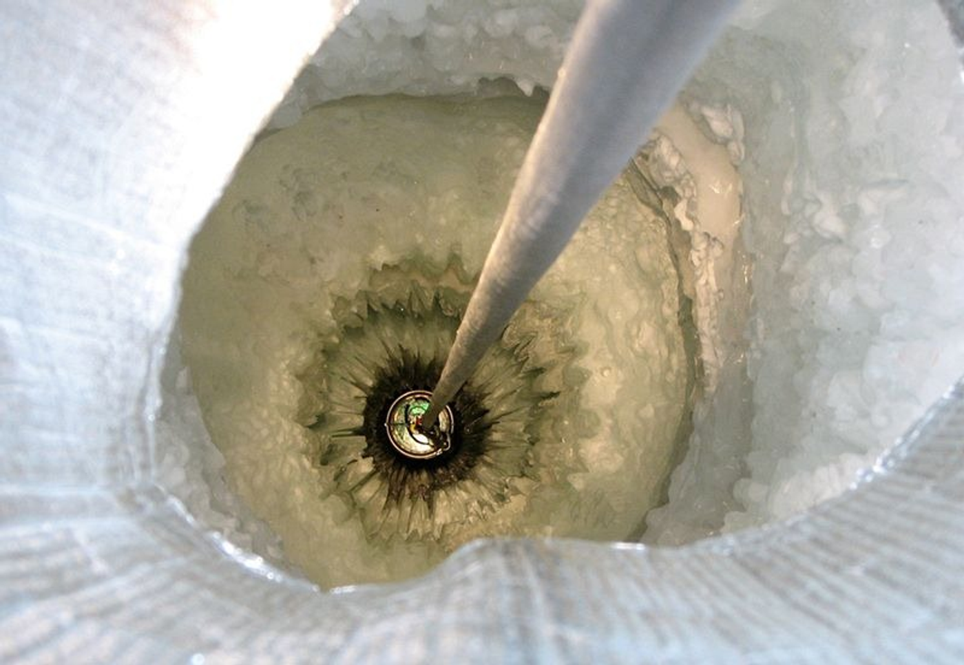 A Digital Optical Module (DOM) is lowered into a 2,500 meter-deep hole in the ice.