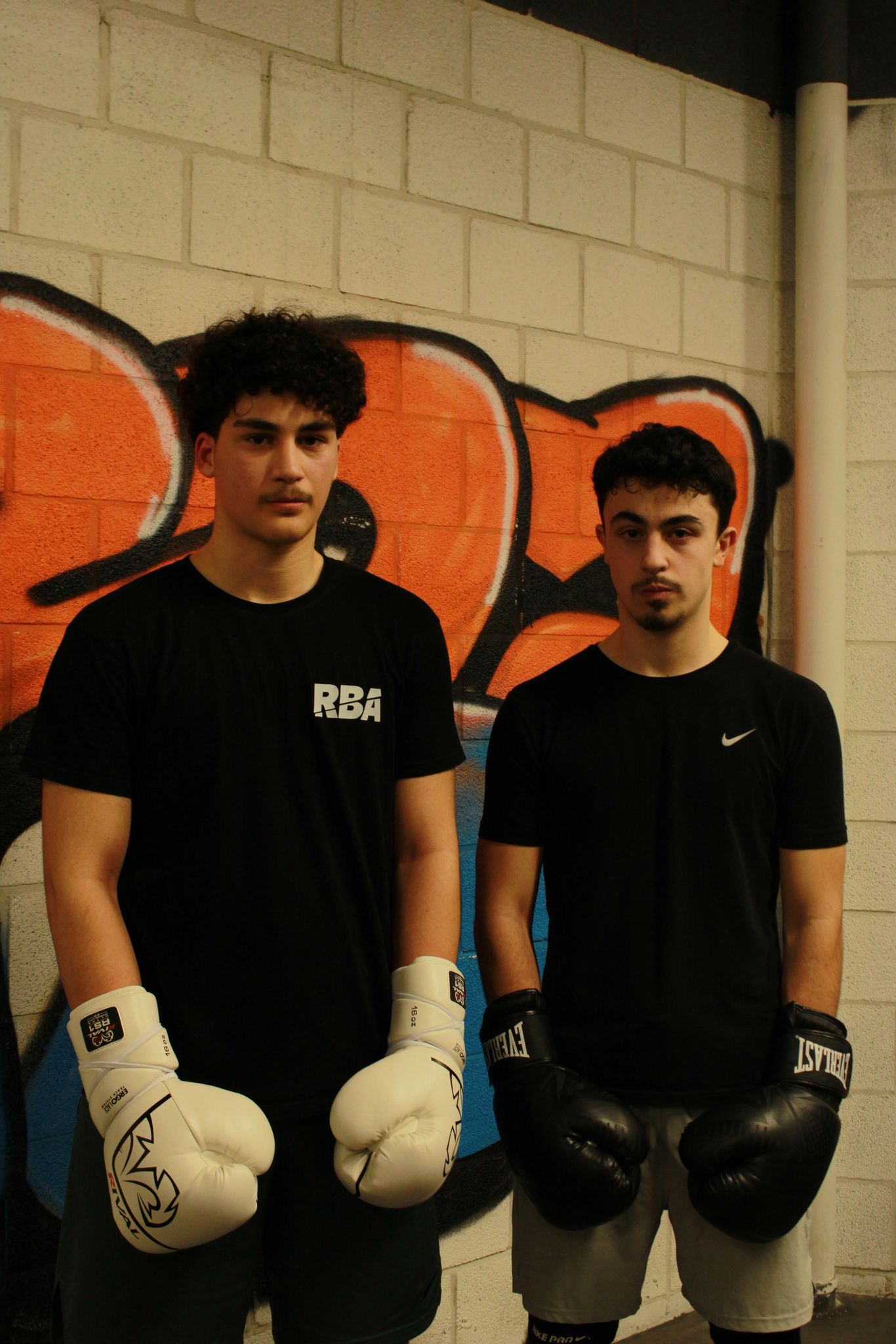 2 jongemannen met witte en zwarte bokshandschoenen