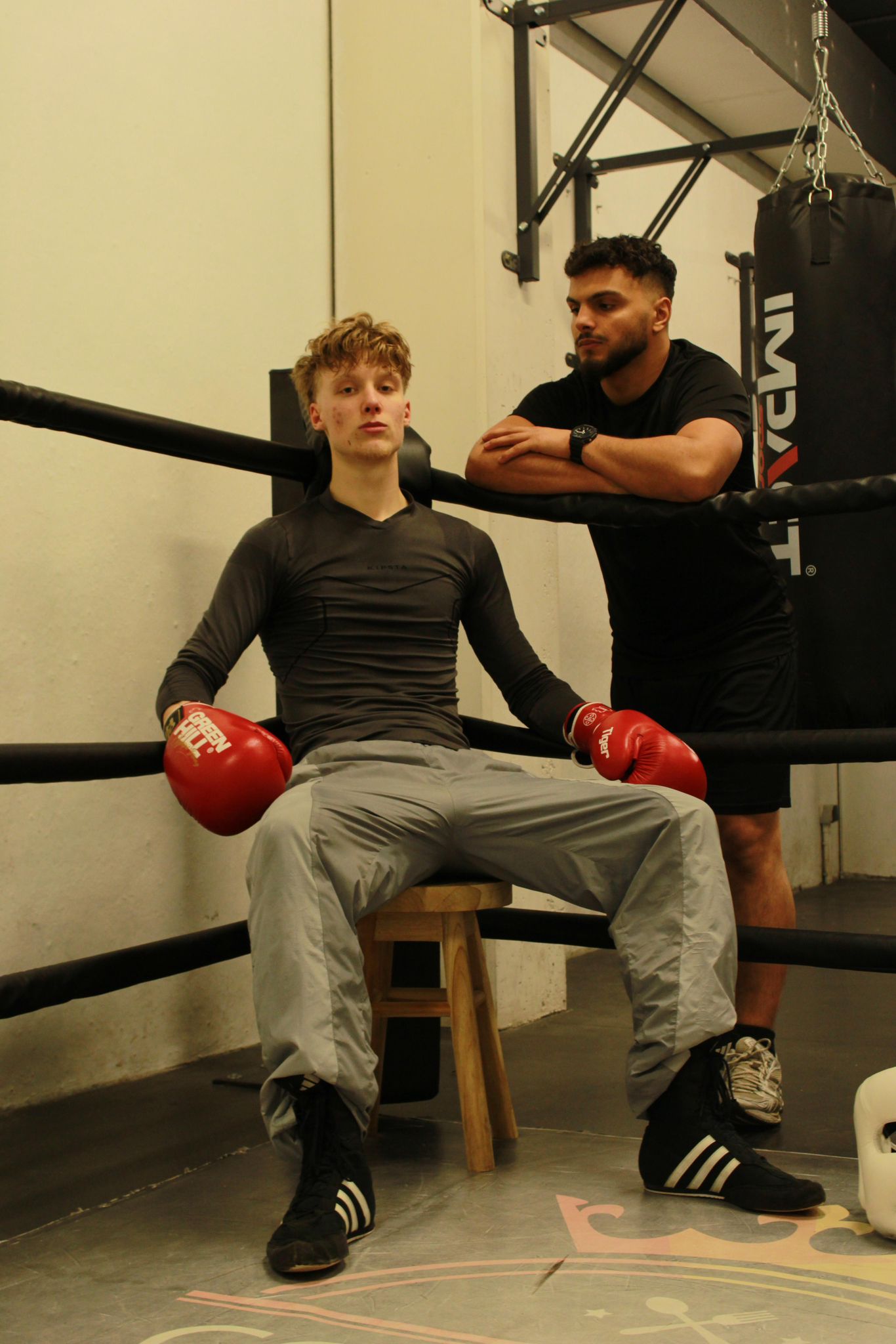 bokser in de hoek met rode bokshandschoenen en trainer Ridvan Orhan
