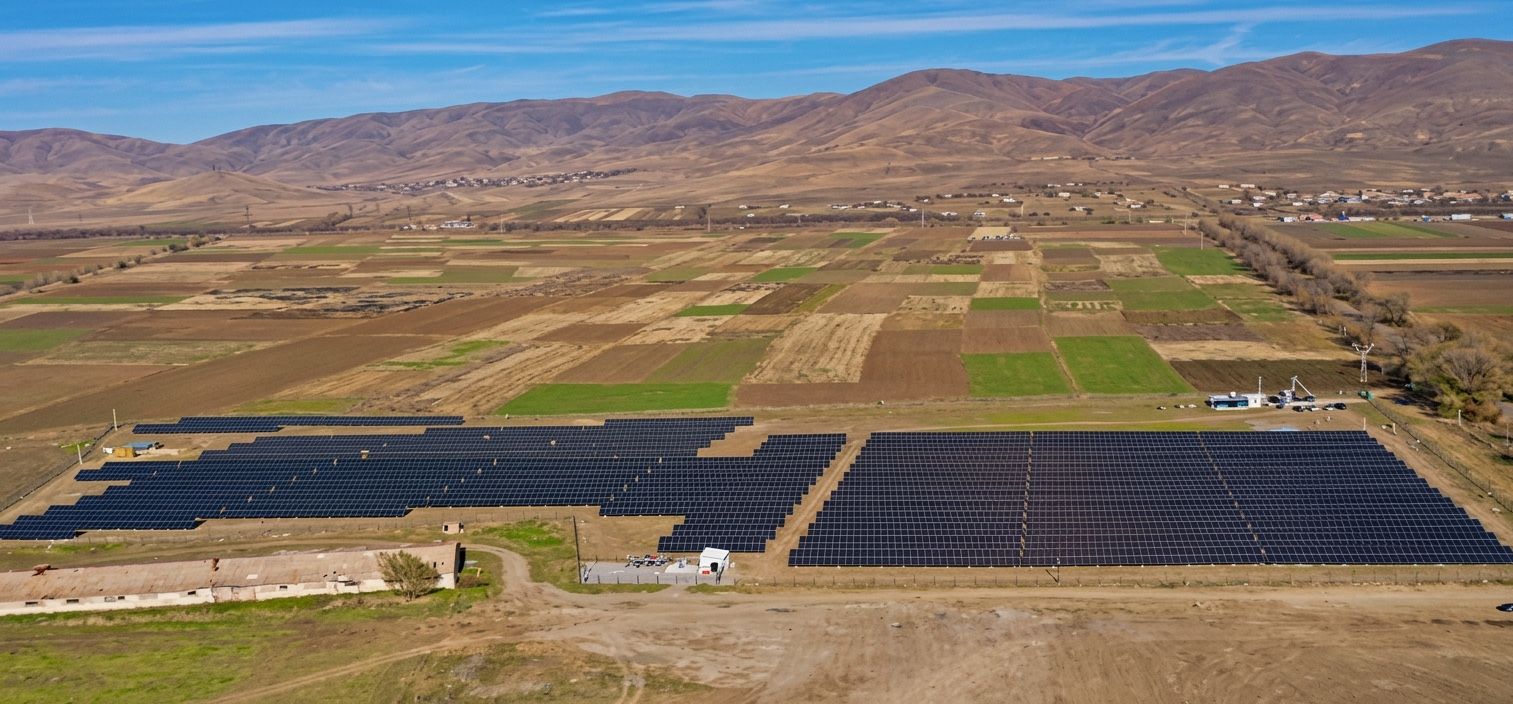 Aerial view of the Stellar Energy agrivoltaic plant near Spitak, its solar array set among cultivated fields with hills behind.