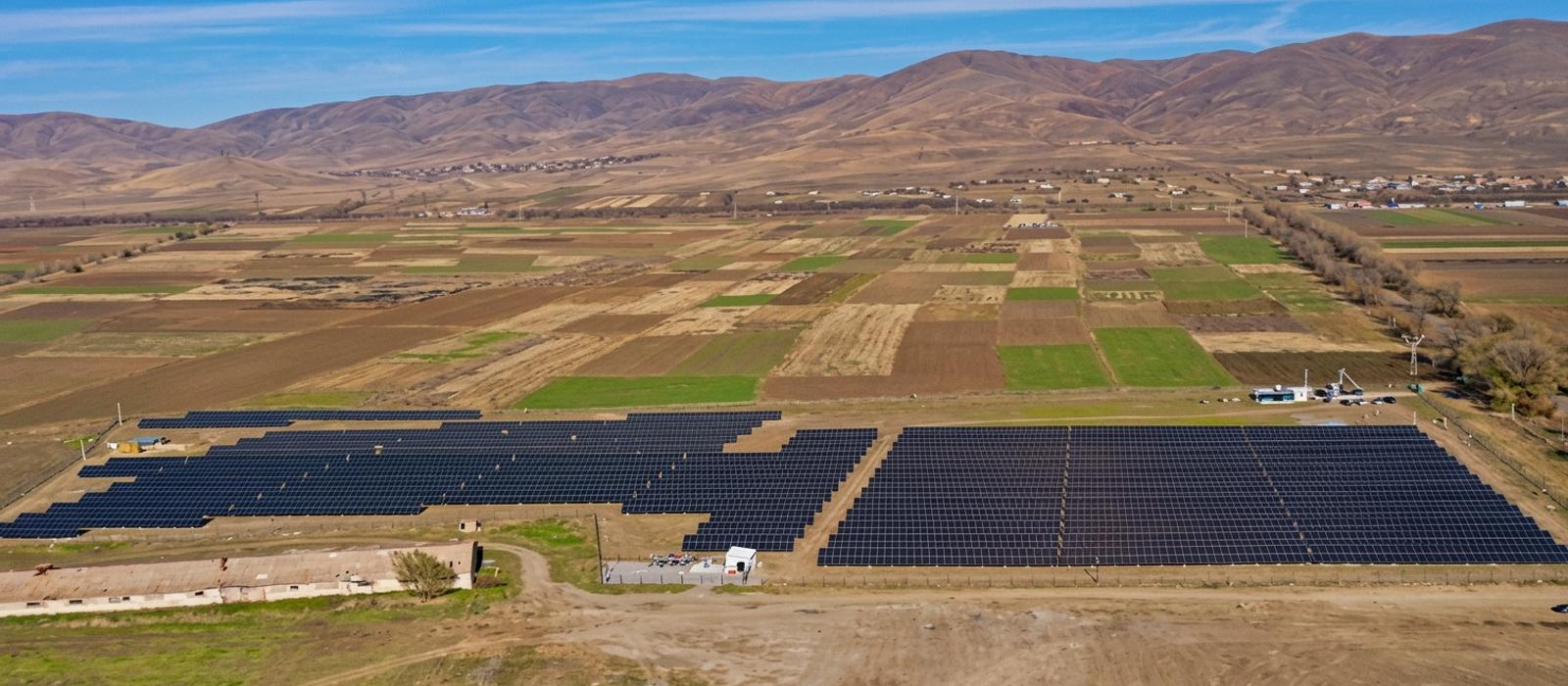 Aerial view of the Stellar Energy agrivoltaic plant near Spitak, its solar array set among cultivated fields with hills behind.