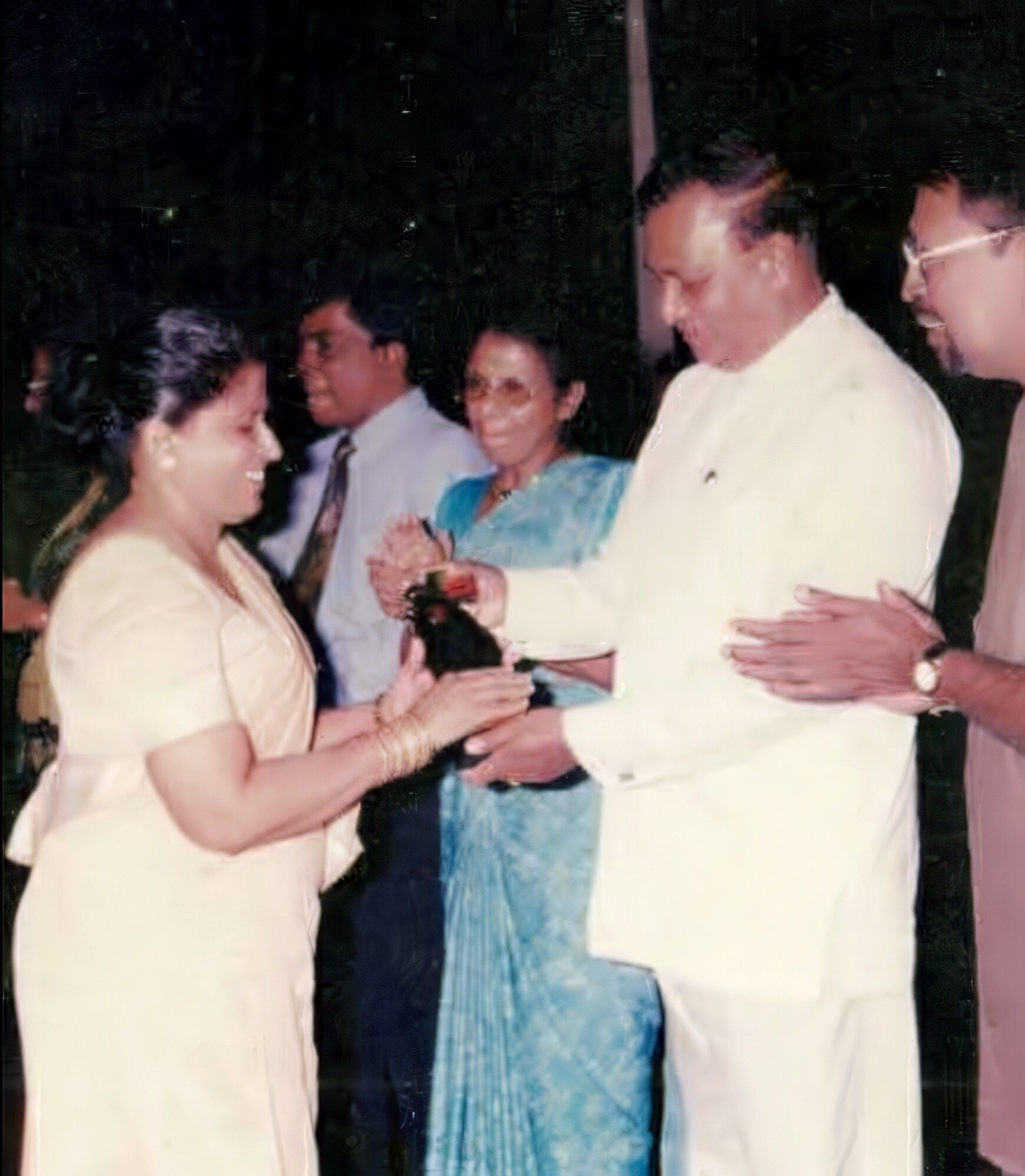 An early photograph: Darshani Chandrasena receives an award from a guest in white national dress