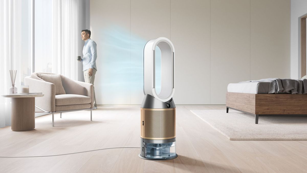 Dyson Purifier Humidify+Cool PH2 in a bright living room, with a man holding a mug by the window