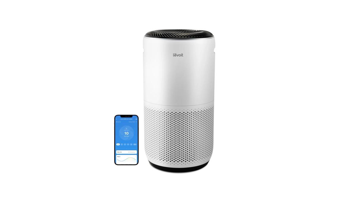 White Levoit Core 400S-P air purifier beside a phone showing its controls.
