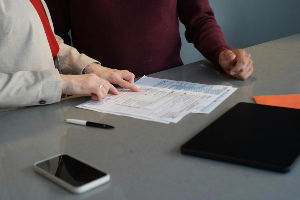 Financial advisor reviewing tax documents with a client at a table