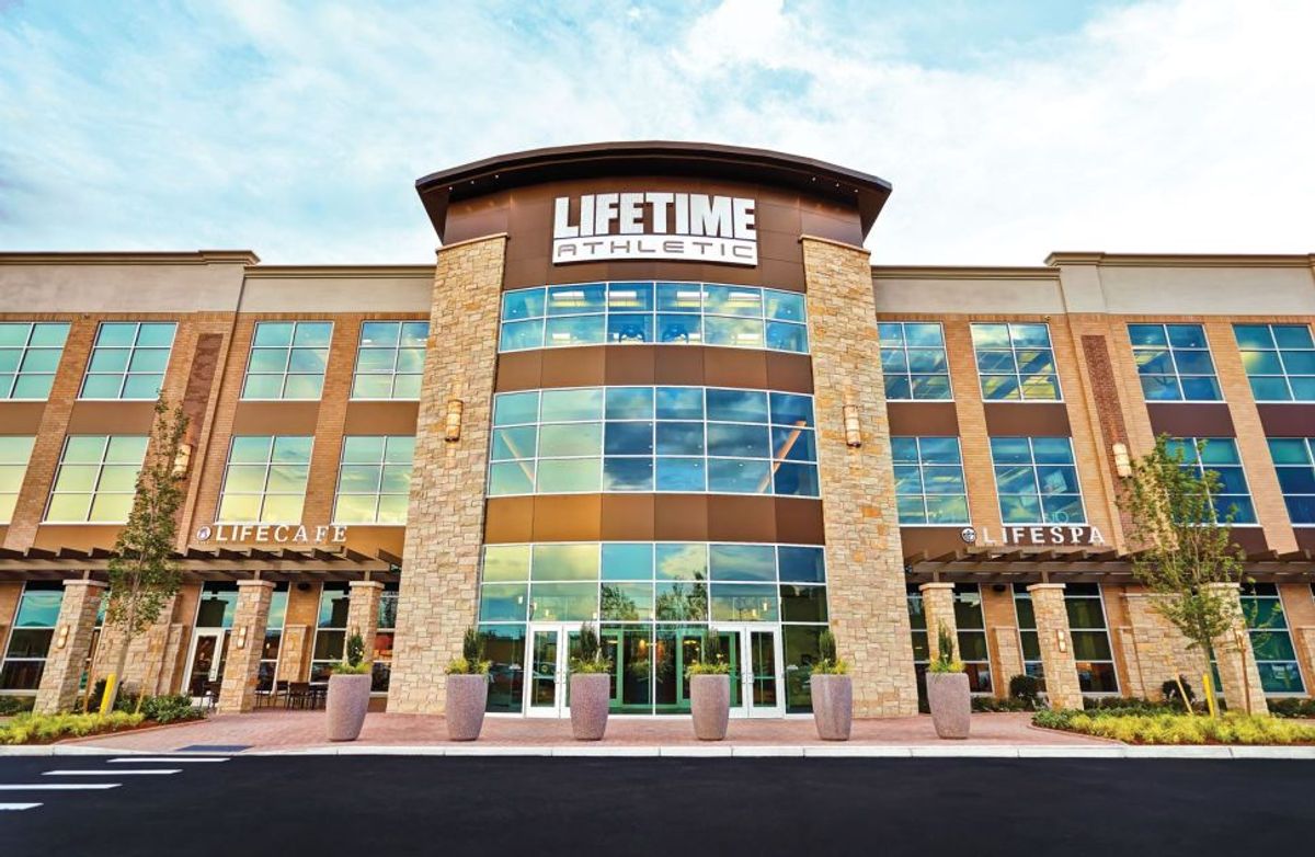 LIFETIME ATHLETIC fitness center exterior with modern glass architecture, promoting health and wellness services for injury recovery and physical therapy.