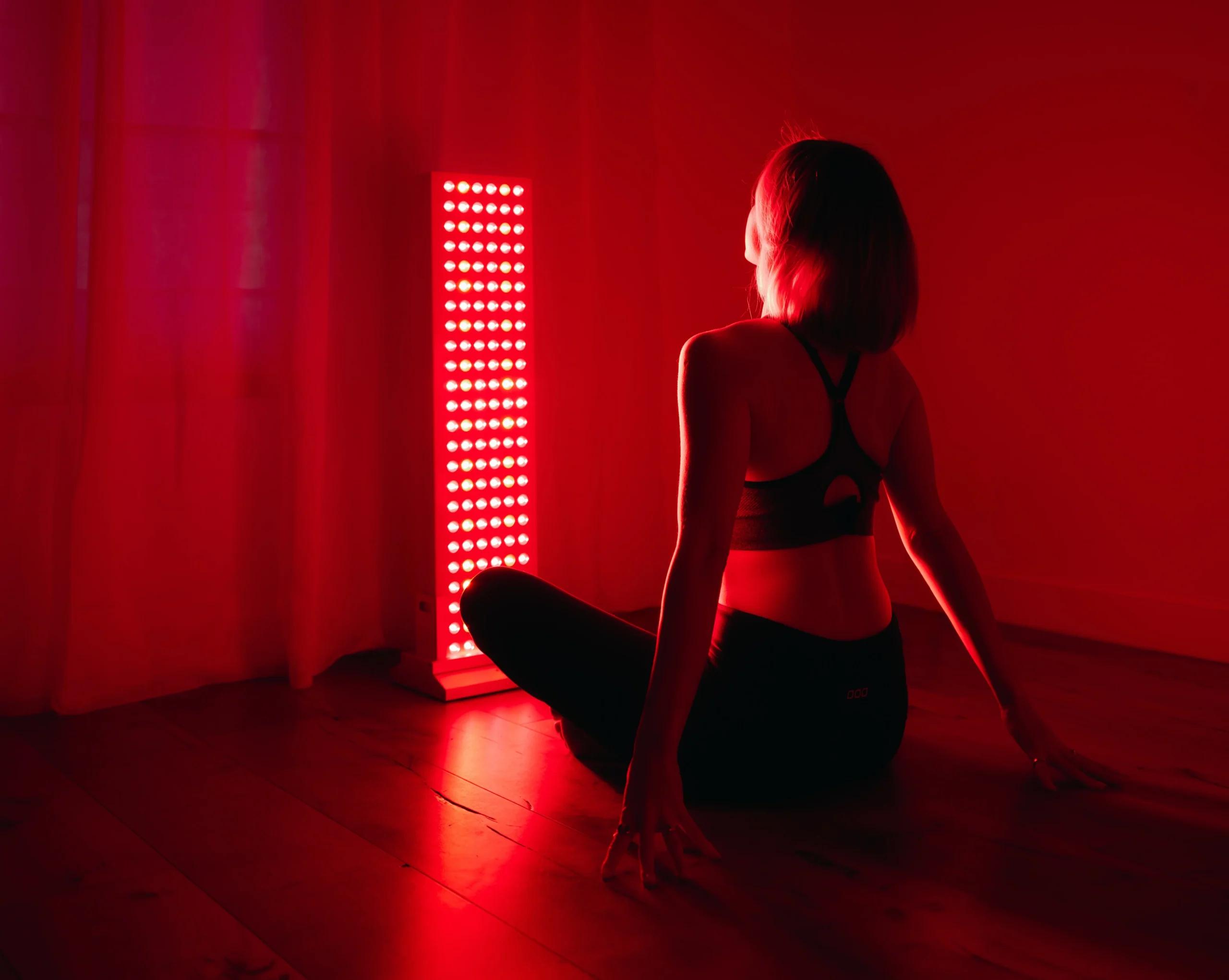 Red light therapy panel emitting deep red and near-infrared light for at-home recovery sessions