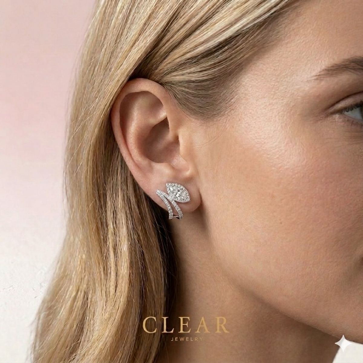 Close portrait of a blonde model with a pavé diamond vine ear ornament against soft rose.