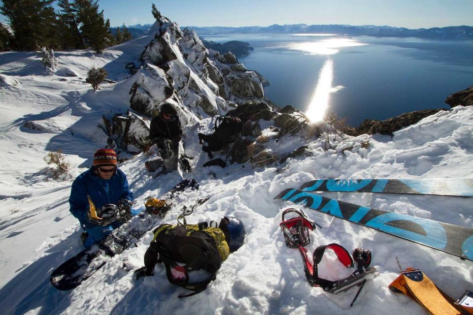Splitboarders transitioning on the rocky summit of Rubicon Peak above Lake Tahoe