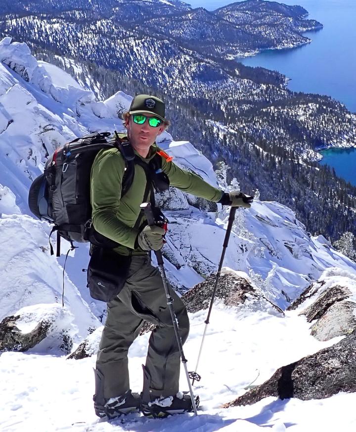 Anthony Cupaiuolo splitboarding on a rocky snow ridge