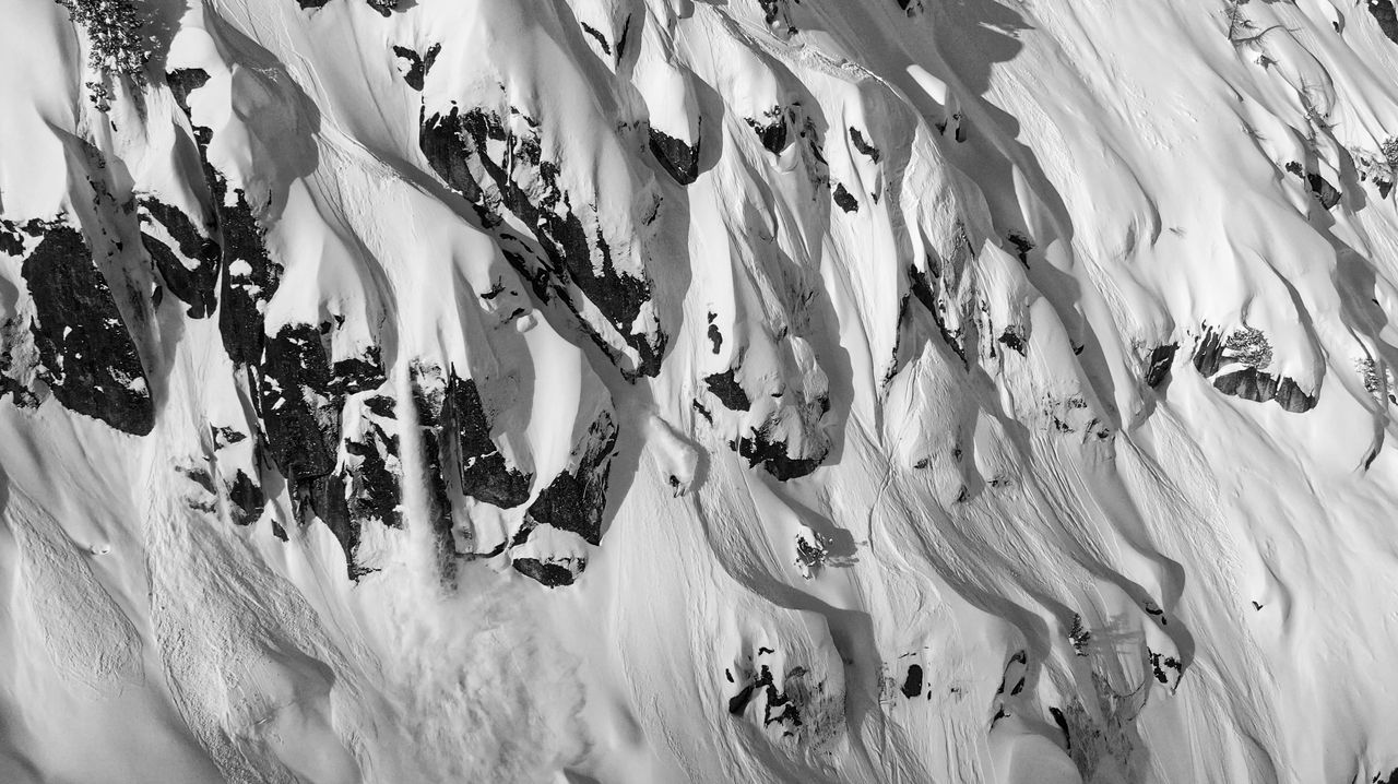 Black and white aerial view of steep, rocky snow chutes