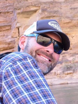 Greg Garrison in a cap and sunglasses