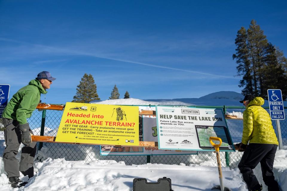 Volunteers installing avalanche awareness and etiquette signs at a Tahoe trailhead