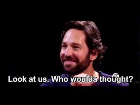 Paul Rudd sitting at a table and smiling saying, "Look at us. Who woulda thought?"