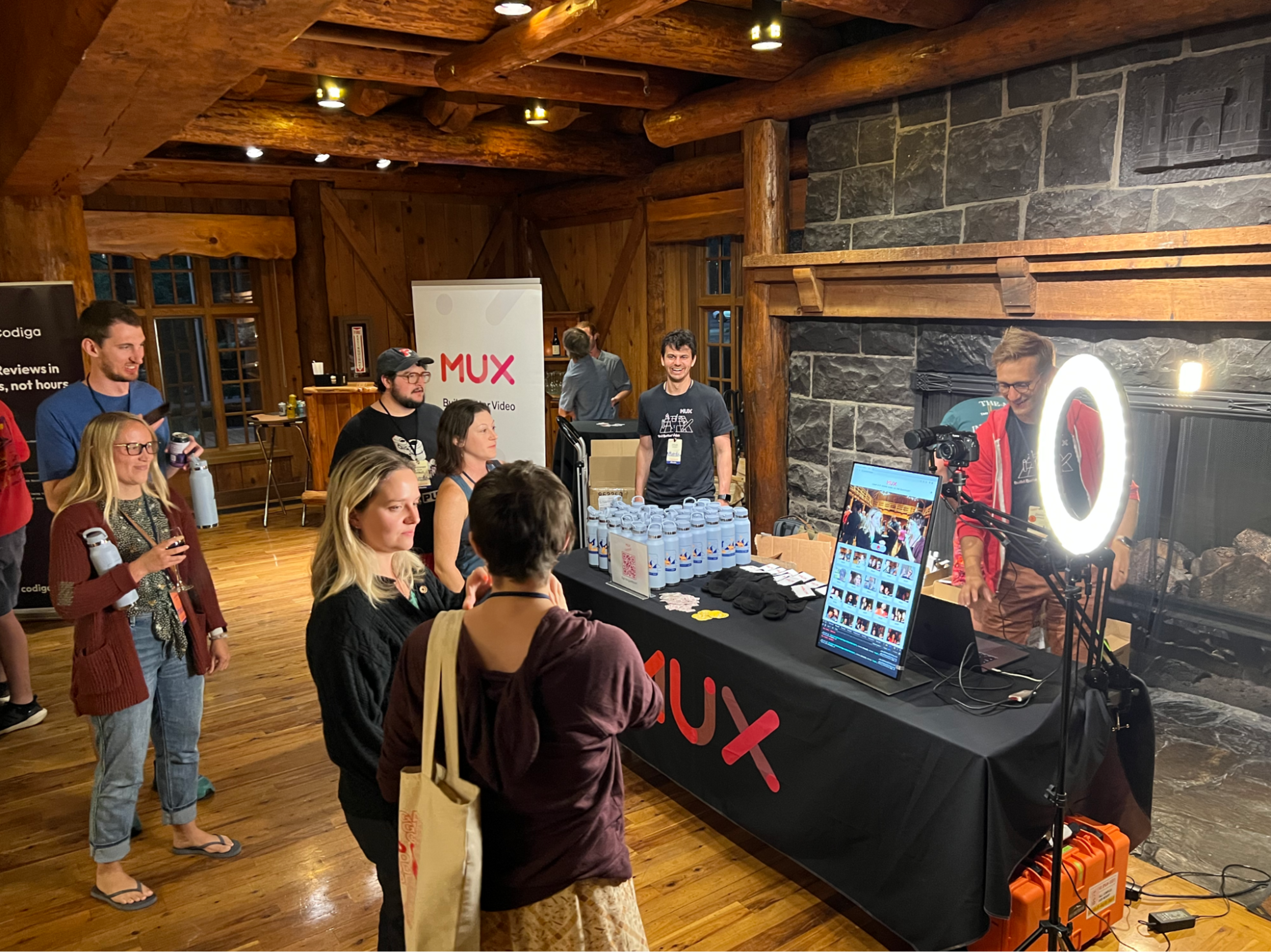 A group of people standing in front of the video guestbook inside of the main lodge.