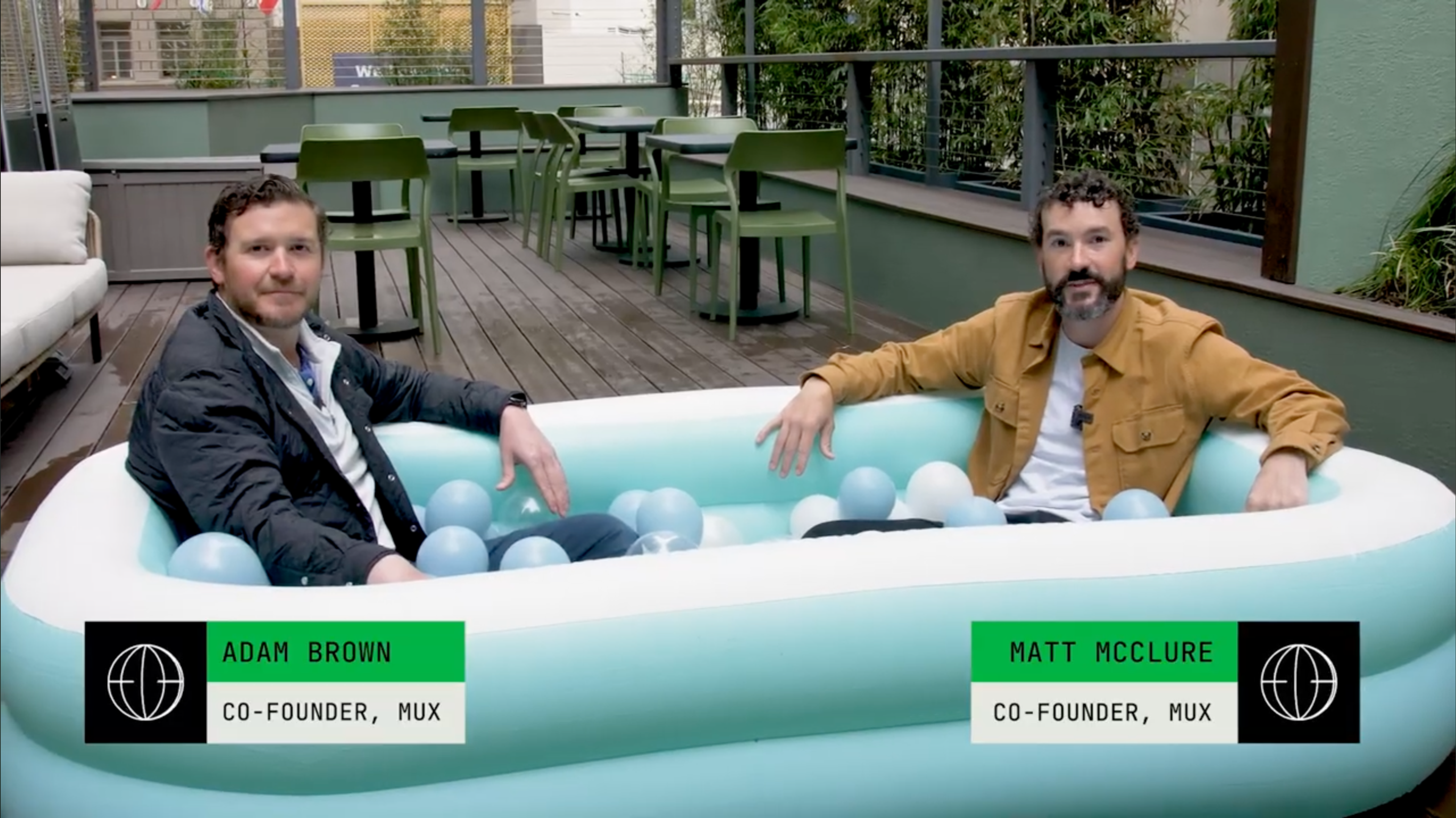 Two Mux founders, chilling in a (pretend) hot tub, discussing Mux Robots