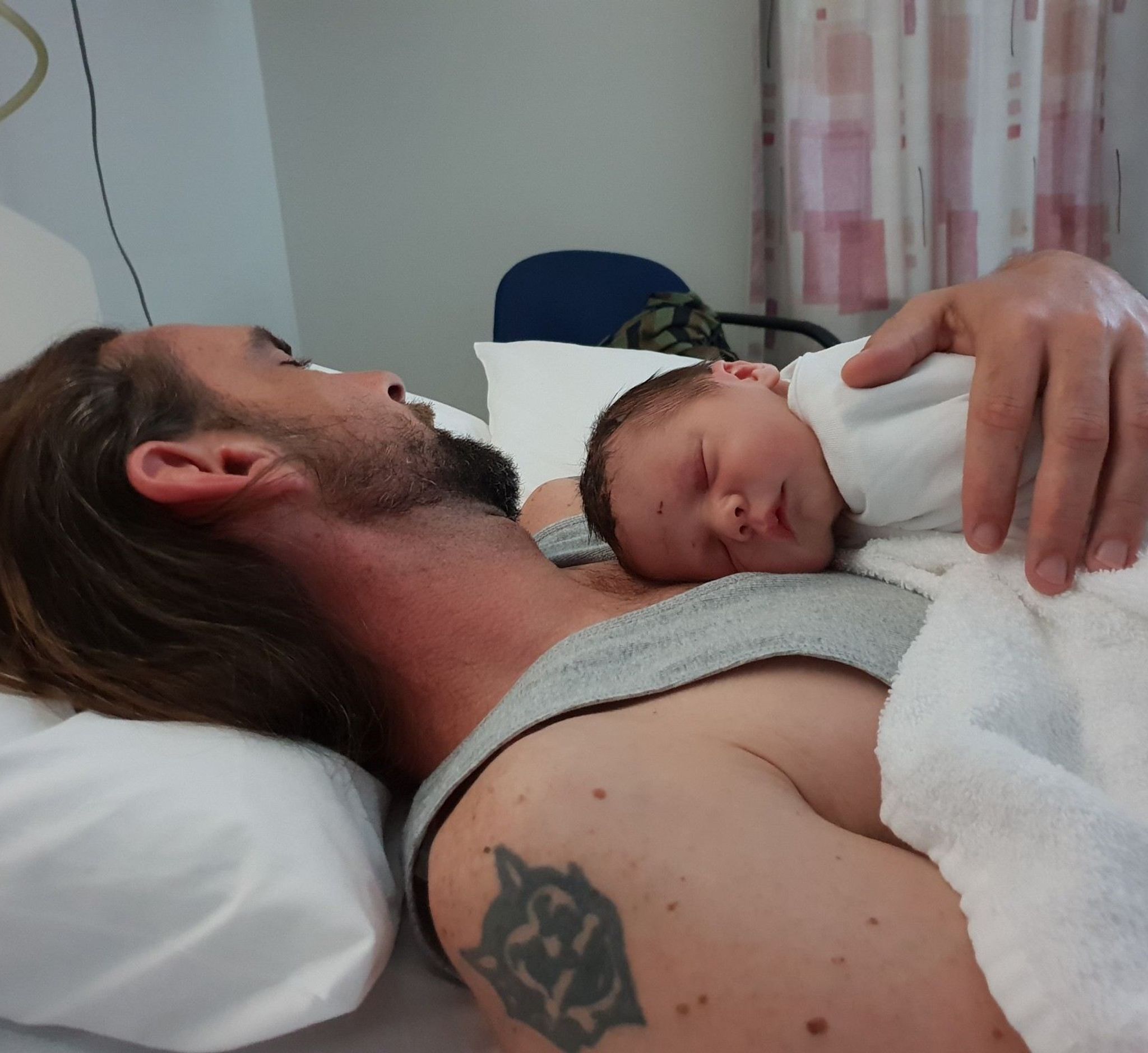 Chris laying down with newborn baby