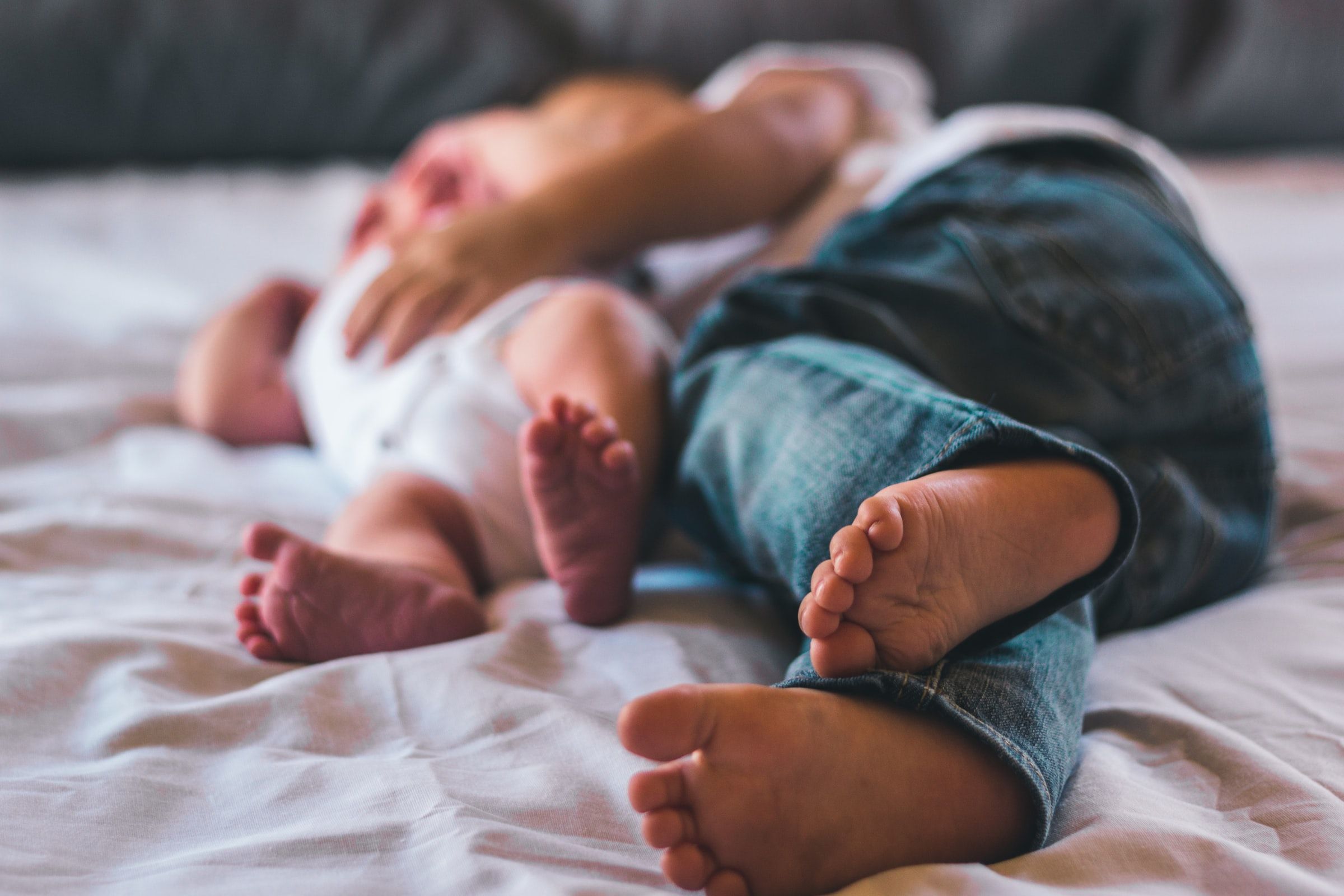 Toddler and baby laying together