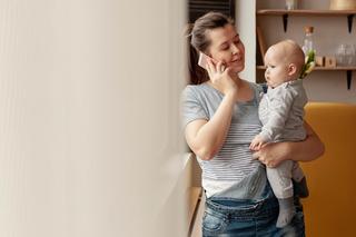 Mother holding baby while on the phone