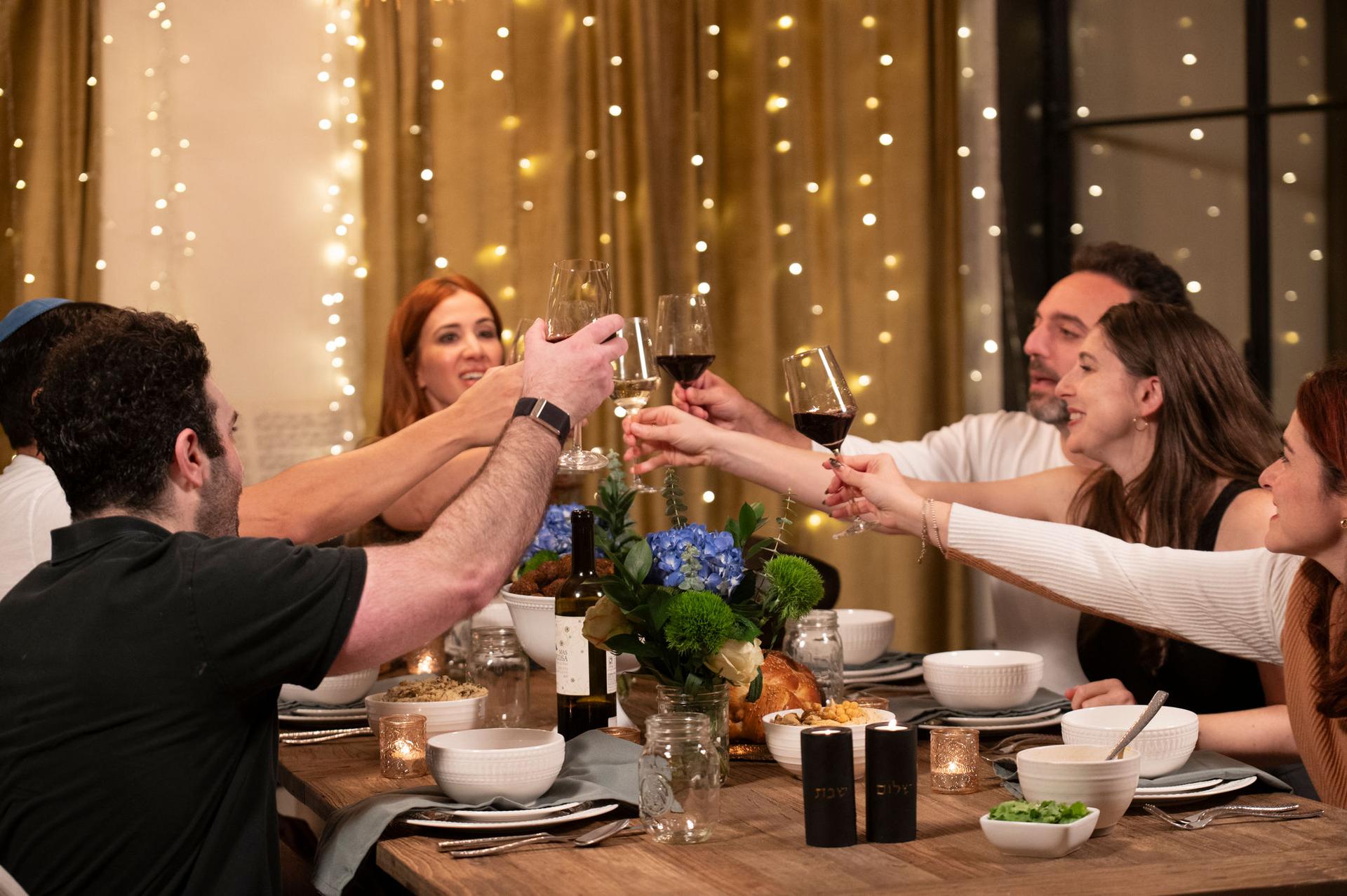 Guests toasting together around a celebratory dinner table