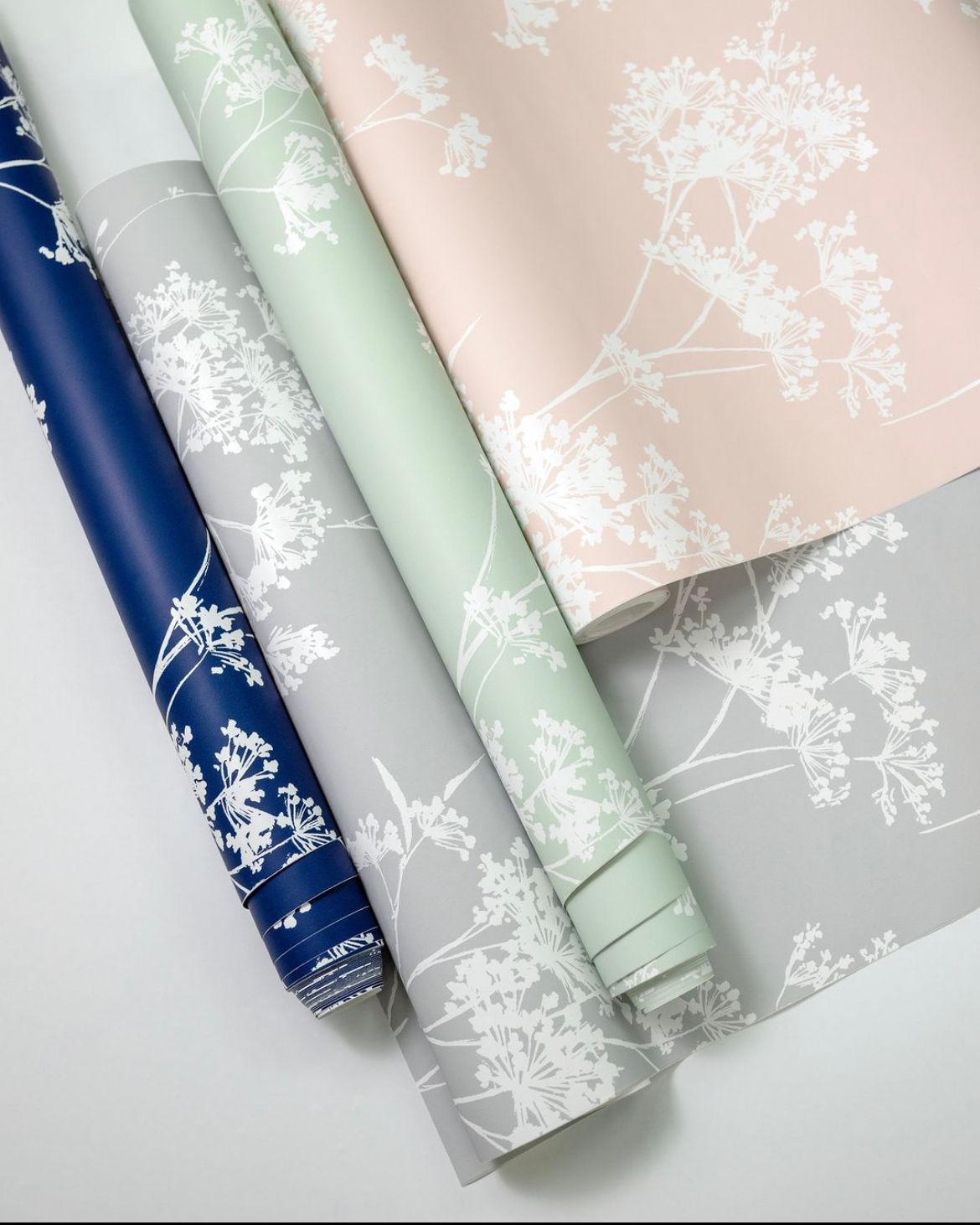Floral silhouette wallpaper rolls in navy, grey, sage, and blush