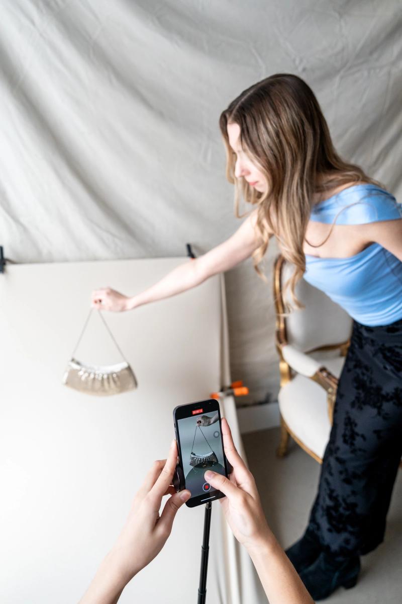 Behind-the-scenes content shoot capturing a handbag on phone video