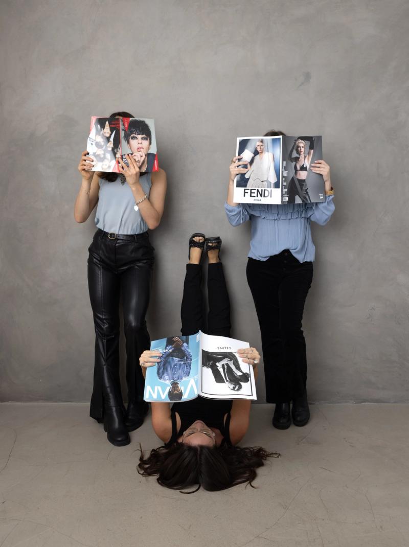 Three SociaLight Media team members holding FENDI, VMAN, and CELINE fashion magazines
