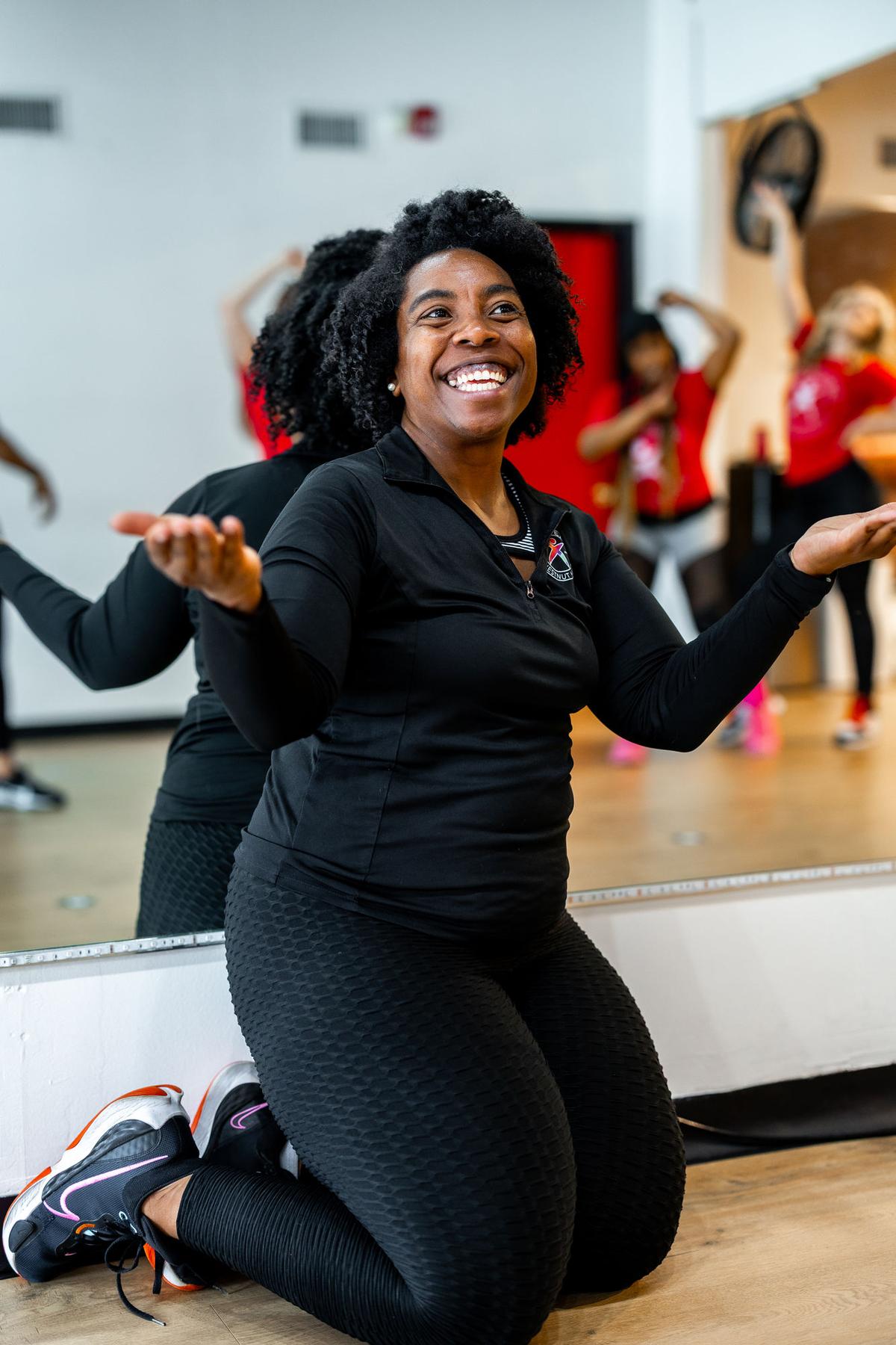 Smiling participant cheering at a dance fitness class