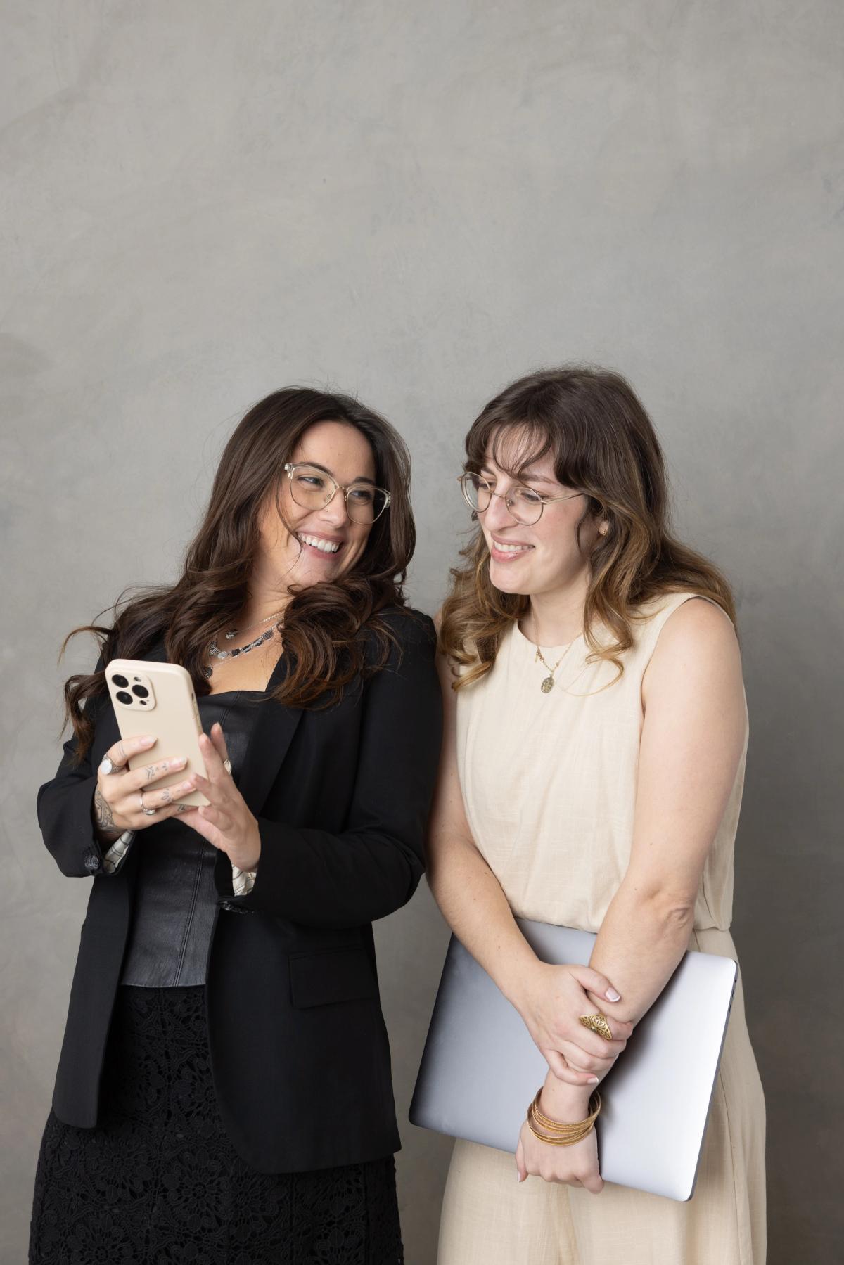 Two SociaLight Media team members reviewing campaign results together on a phone