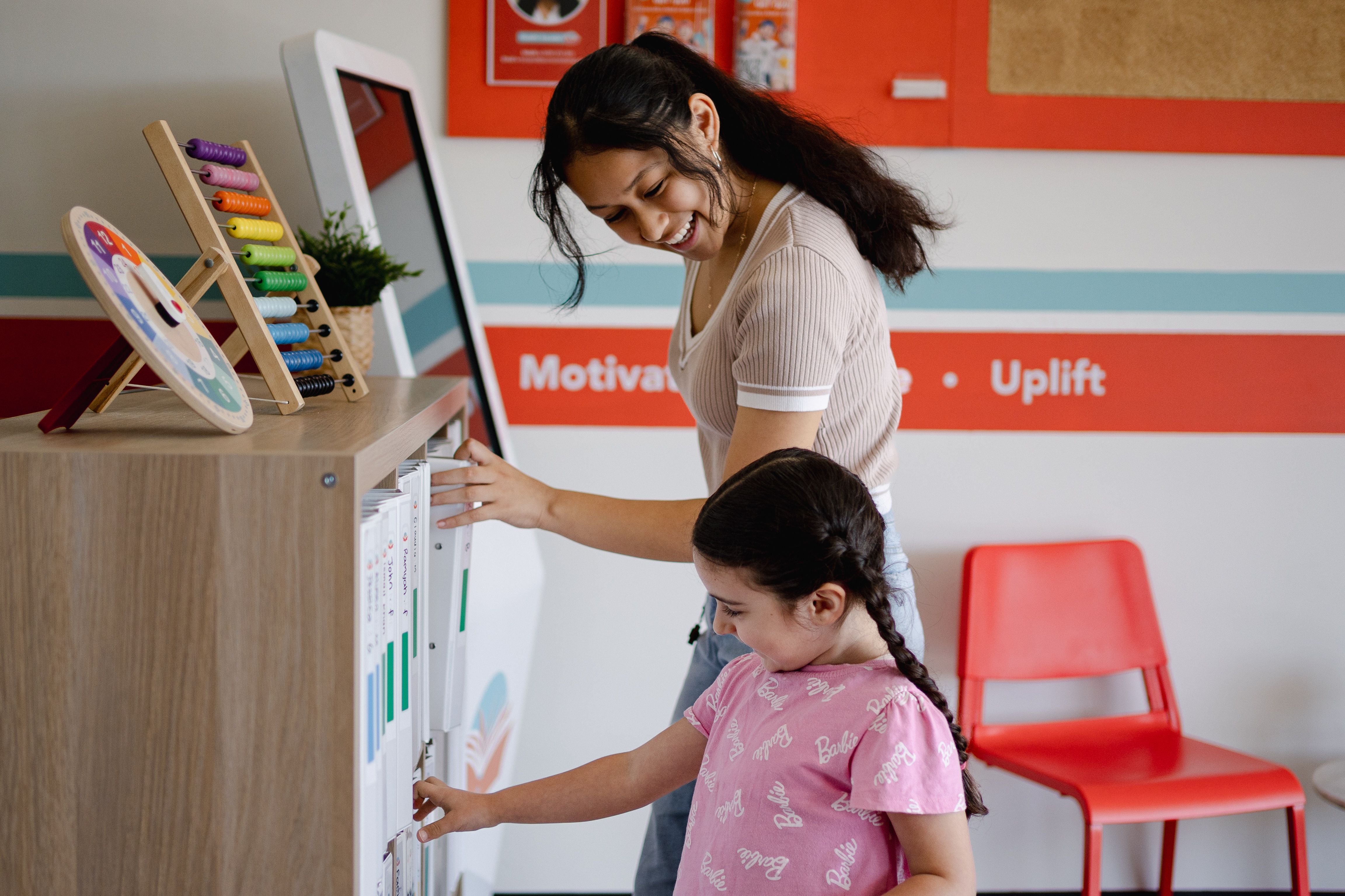 a woman and a little girl are standing next to each other in a waiting room .